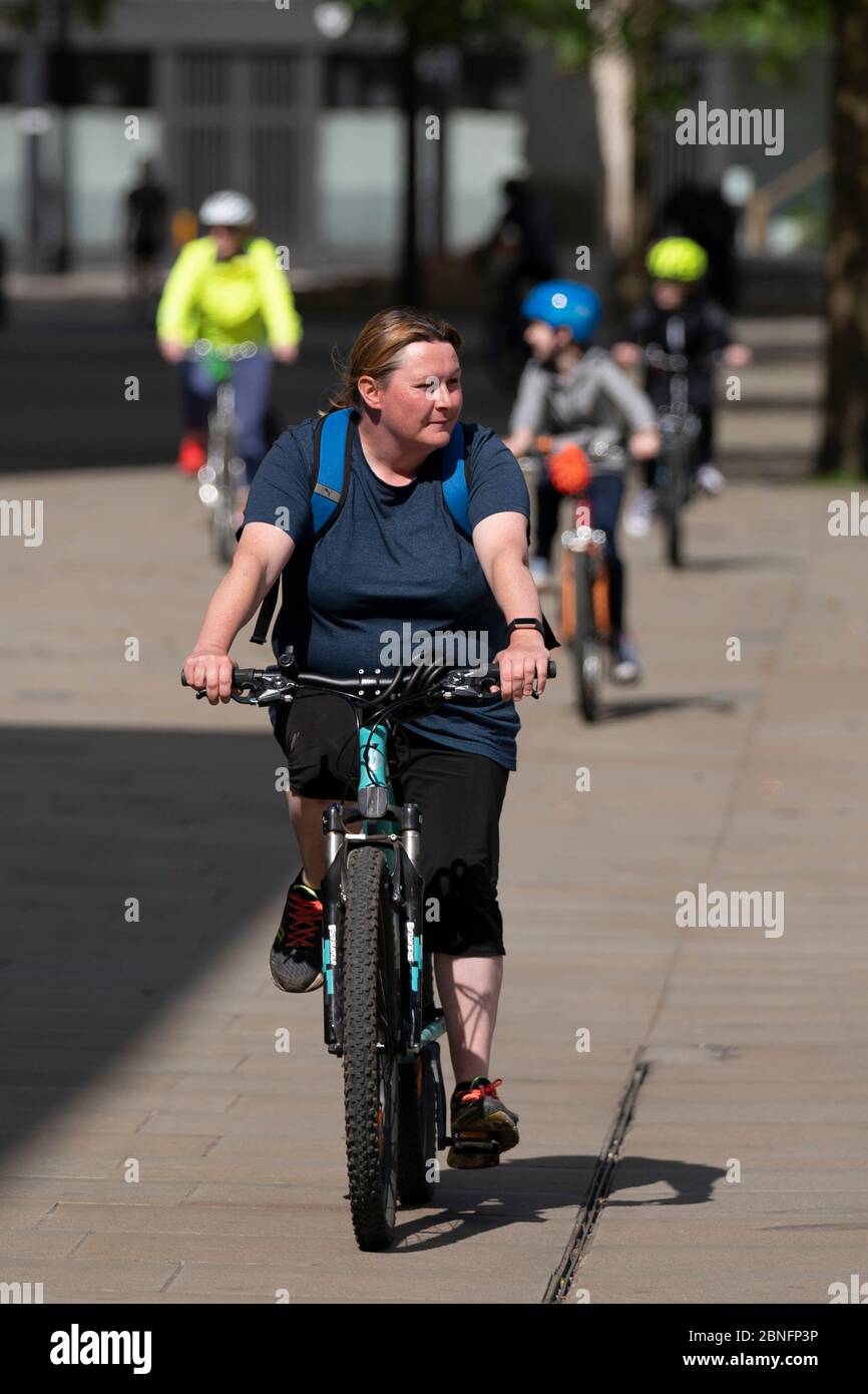 Manchester, Gran Bretagna. 14 maggio 2020. Una donna guida una bicicletta a Manchester, Gran Bretagna, il 14 maggio 2020. Il 9 maggio il Segretario britannico dei Trasporti Grant Shapps ha annunciato un pacchetto da 2 miliardi di sterline (2.5 miliardi di dollari statunitensi) per incoraggiare la bicicletta e il camminare in mezzo alla pandemia COVID-19, mentre altri 346 pazienti sono morti nel paese. La mossa è arrivata mentre il governo si sforza di raddoppiare il ciclismo e aumentare a piedi entro il 2025 con un piano nazionale di ciclismo che dovrebbe essere pubblicato nel mese di giugno. Credit: Jon Super/Xinhua/Alamy Live News Foto Stock