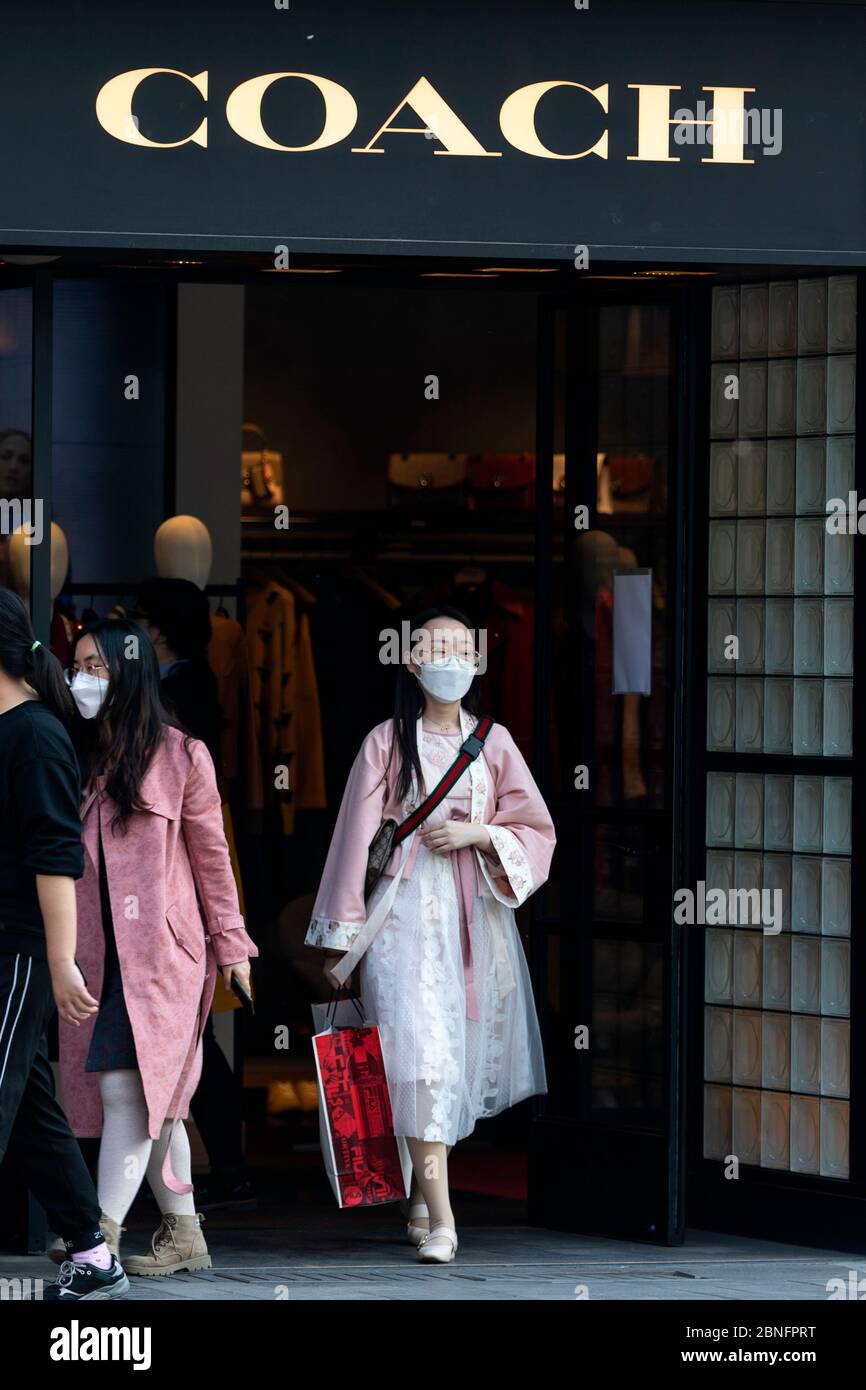 La gente esce da un negozio di pullman a Pechino, Cina, 6 aprile 2020. Foto Stock