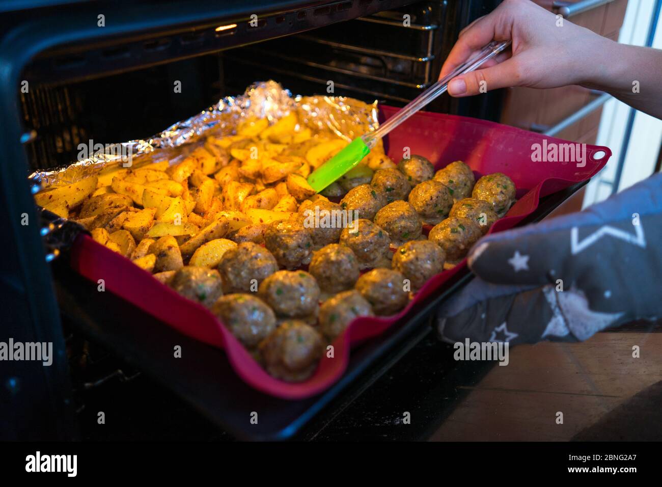 Closeup di polpette appena sfornate e zeppe di patate Foto Stock