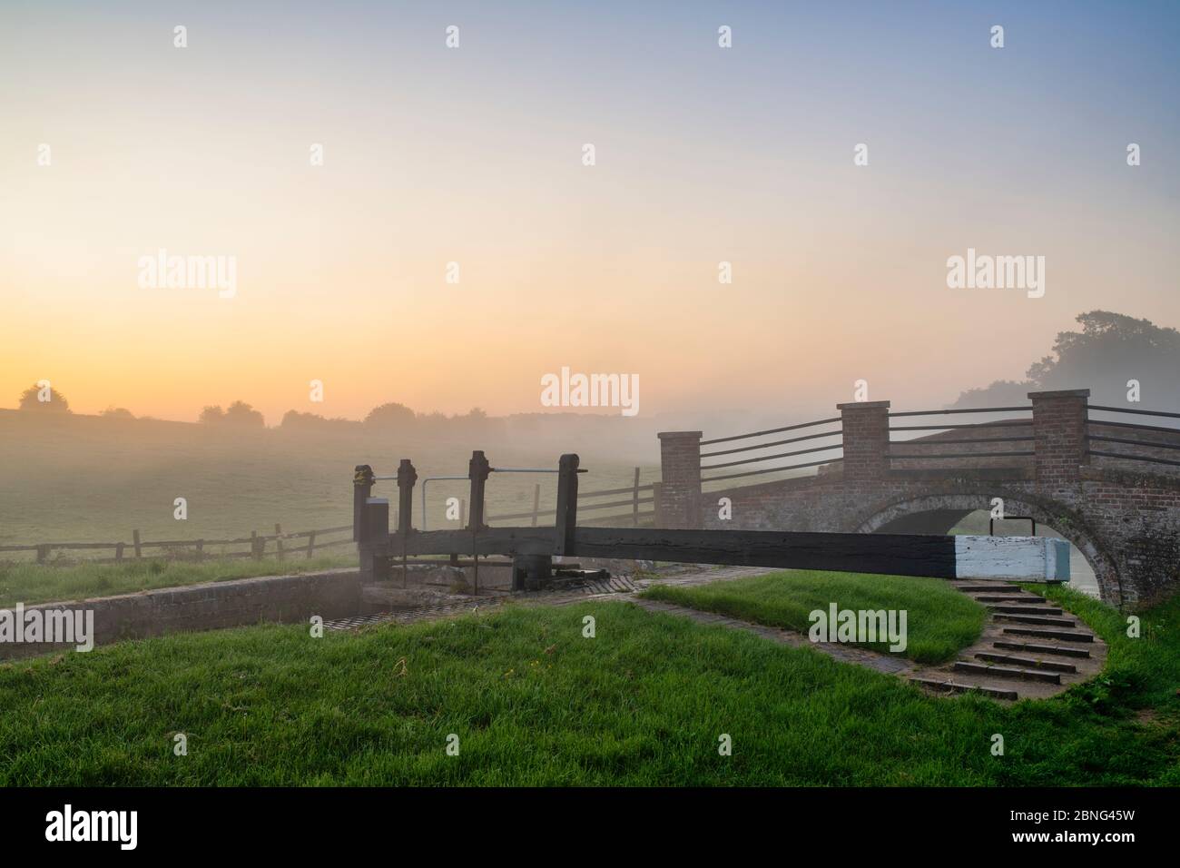 Chiudere e fare un ponte nella nebbia sul canale Oxford in una mattina primaverile subito dopo l'alba. Upper Heyford, Oxfordshire, Inghilterra Foto Stock
