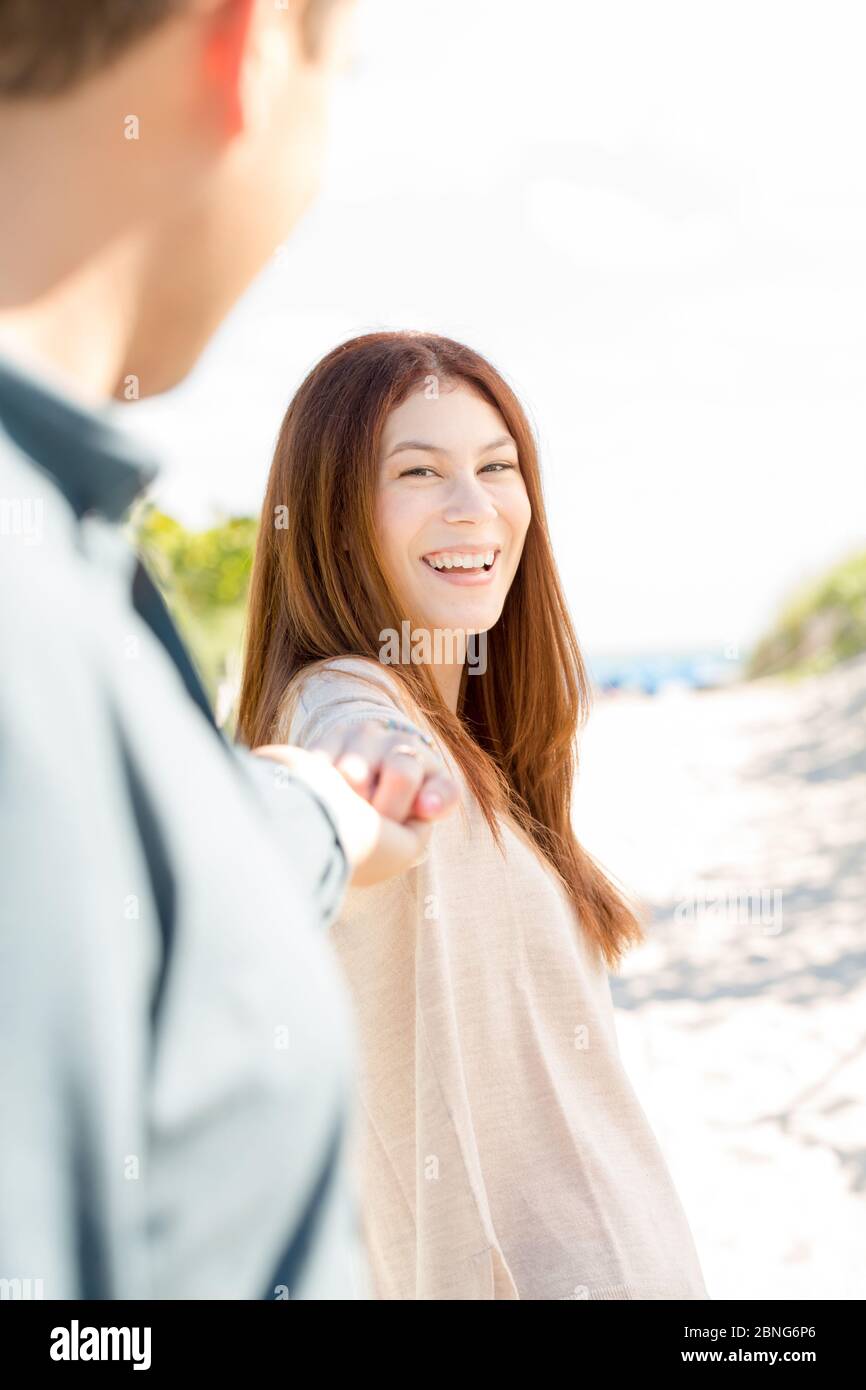 Giovane coppia felice ridendo e tenendo le mani. Foto Stock