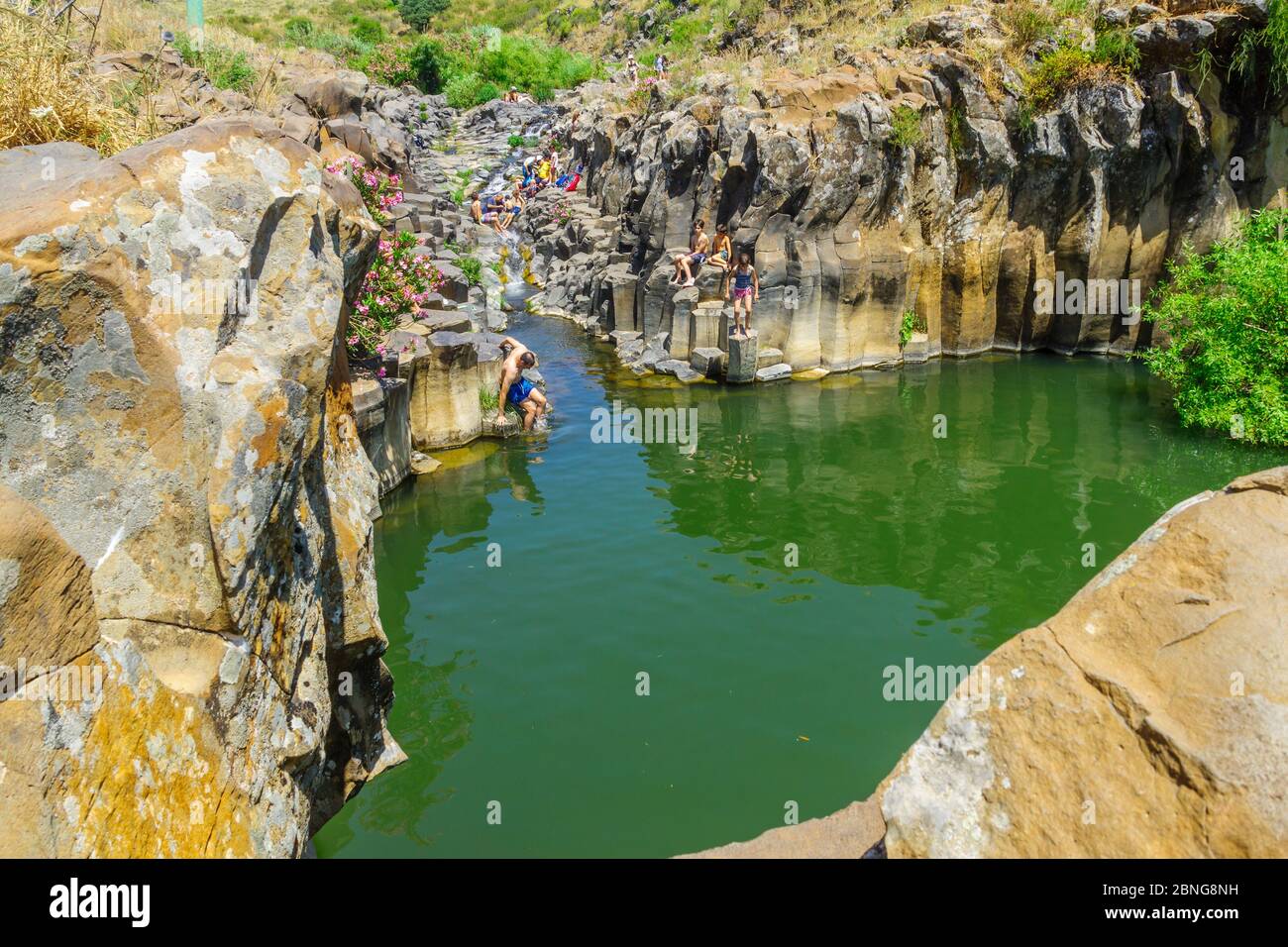 Qatsrin, Israele - 12 maggio 2020: Vista della piscina Zavitan con colonne esagonali, con i visitatori che fanno il bagno, nella Riserva Naturale della Foresta di Yehudiya, l'altezza del Golan Foto Stock
