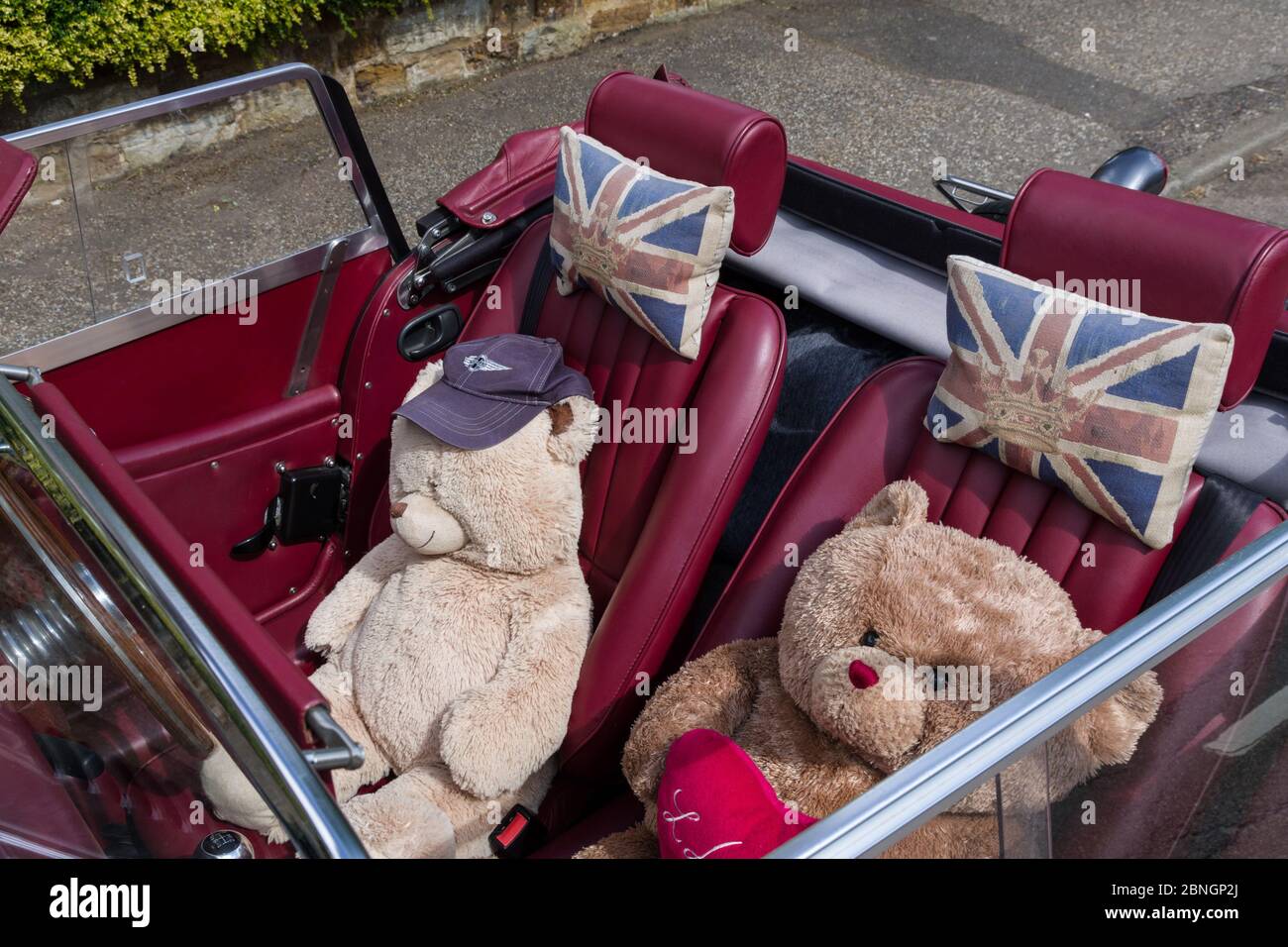 Ve Day 75th Anniversary festeggiamenti nel villaggio di Little Houghton, Northamptonshire, Regno Unito: Due orsacchiotti in un roadster Morgan d'epoca Foto Stock