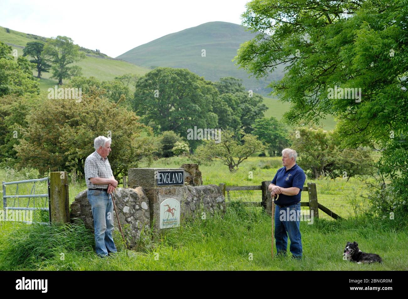 Due vicini agricoli, uno scozzese (a destra) e l'altro inglese chiacchierano sul confine con la Scozia vicino a Kirk Yetholm, Scozia. Foto Stock