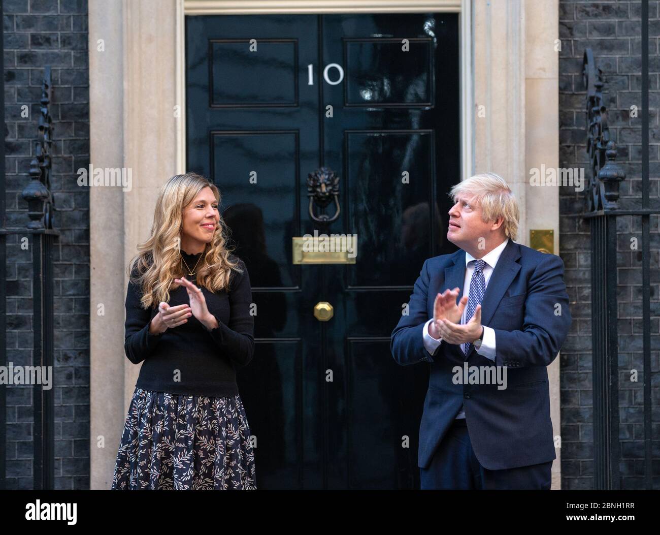 Il primo ministro, Boris Johnson, è Unito sui gradini di Downing Street 10 dal fidanzato Carrie Symonds a 'Clap for Carers' che sostiene l'NHS. Foto Stock