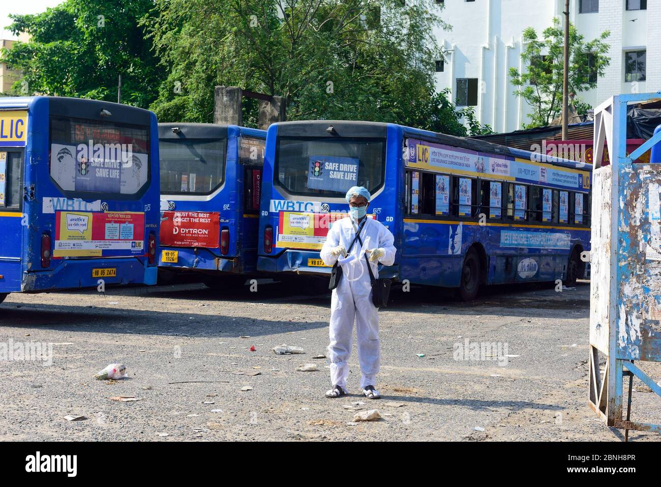 Un conduttore di autobus che indossa un equipaggiamento protettivo attende che il servizio di autobus riprenda in una stazione degli autobus. Il governo dello stato del Bengala occidentale ha deciso di consentire agli operatori di autobus di trasportare solo 20 passeggeri alla volta con misure rigorose di salute e sicurezza, mentre il governo apre i trasporti. Foto Stock