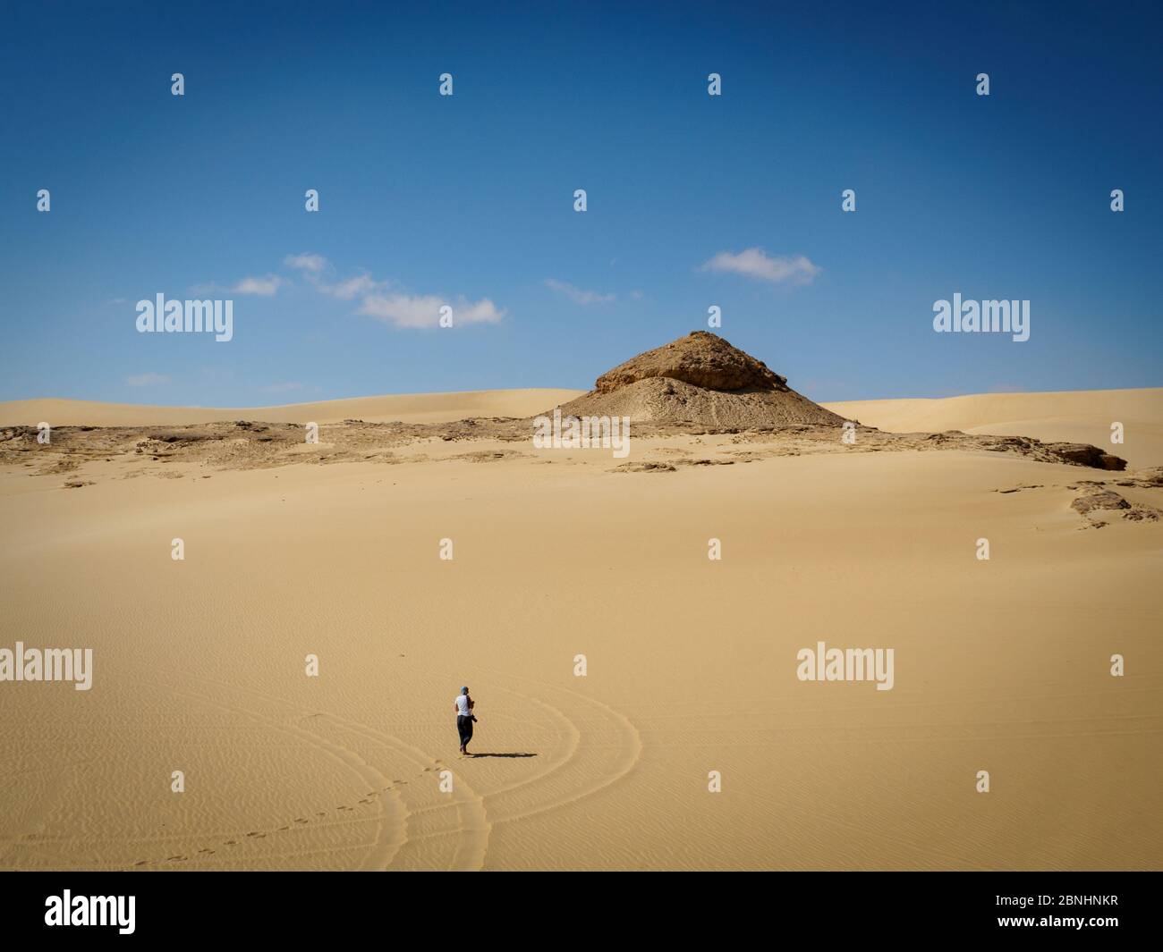 Una donna che si prende una passeggiata nel deserto paesaggio spettacolare vicino Siwa, Egitto Foto Stock