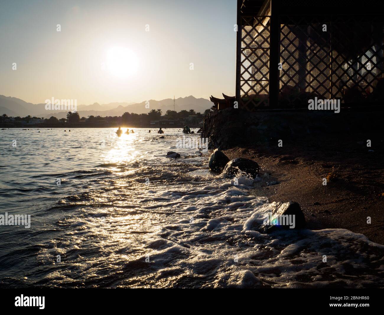 Uno sguardo su Dahab e sulle montagne sinain al tramonto dall'acqua Foto Stock