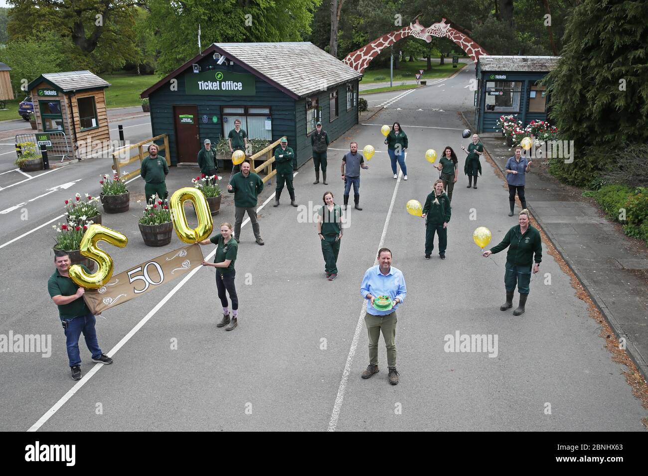 Il direttore generale Gary Gilmour (in fondo al centro) insieme ad altri membri del personale del Blair Drummond Safari Park di Stirling, mentre praticano la distanza sociale mentre celebrano il 50° anniversario del parco. Foto Stock