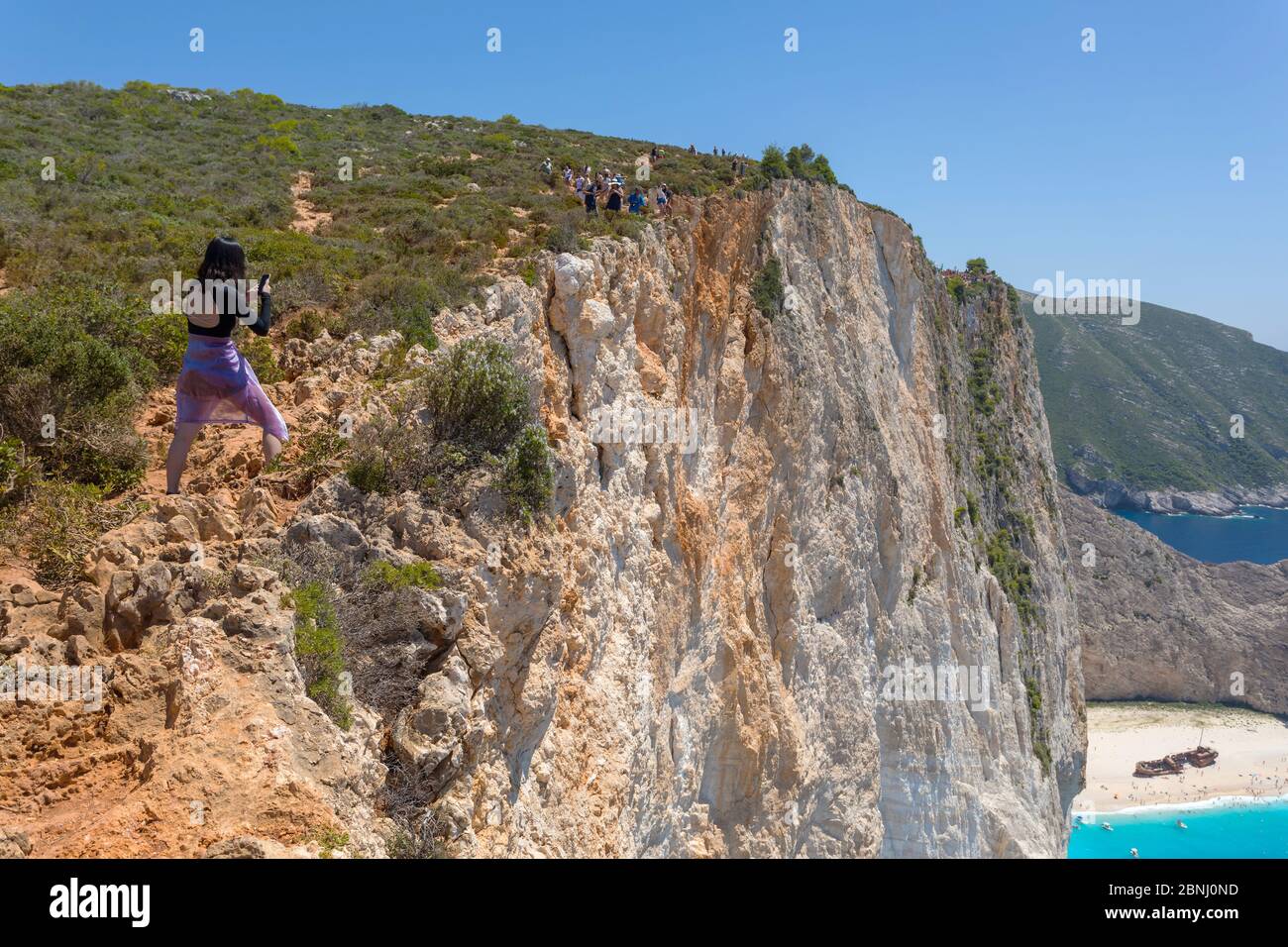 ZANTE, GRECIA - 21 LUGLIO 2018: Turisti ai margini della scogliera per scattare foto della famosa spiaggia con un vecchio naufragio nell'isola di Zante Foto Stock