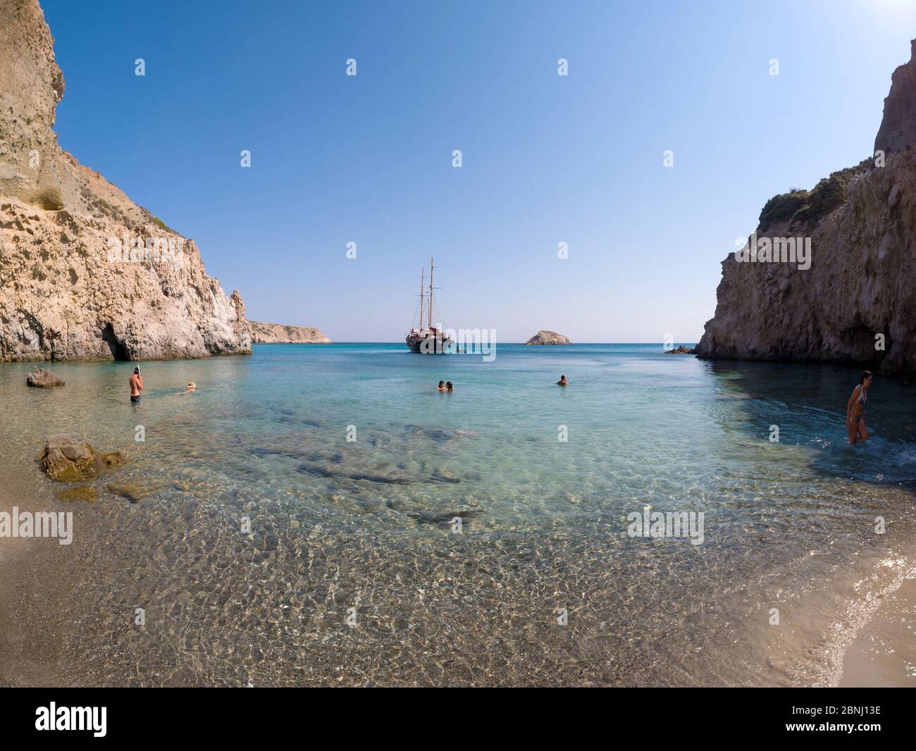 MILOS, GRECIA - 14 LUGLIO 2017: Piccola spiaggia Tsigrado con persone che nuotano in acque cristalline dell'isola di Milos, Grecia Foto Stock