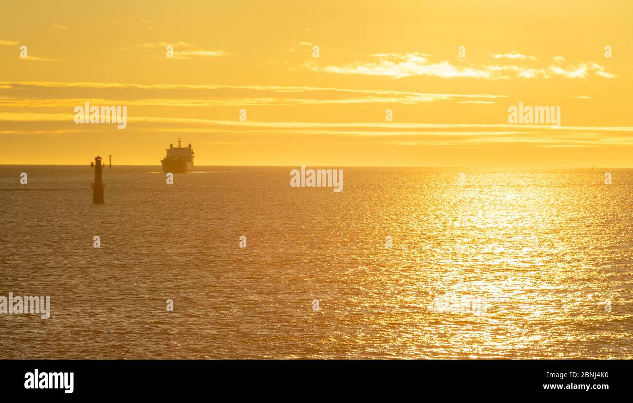 Faro nello stretto tra le isole dell'arcipelago di Stoccolma, illuminato dai raggi del sole, al mattino presto. Foto Stock