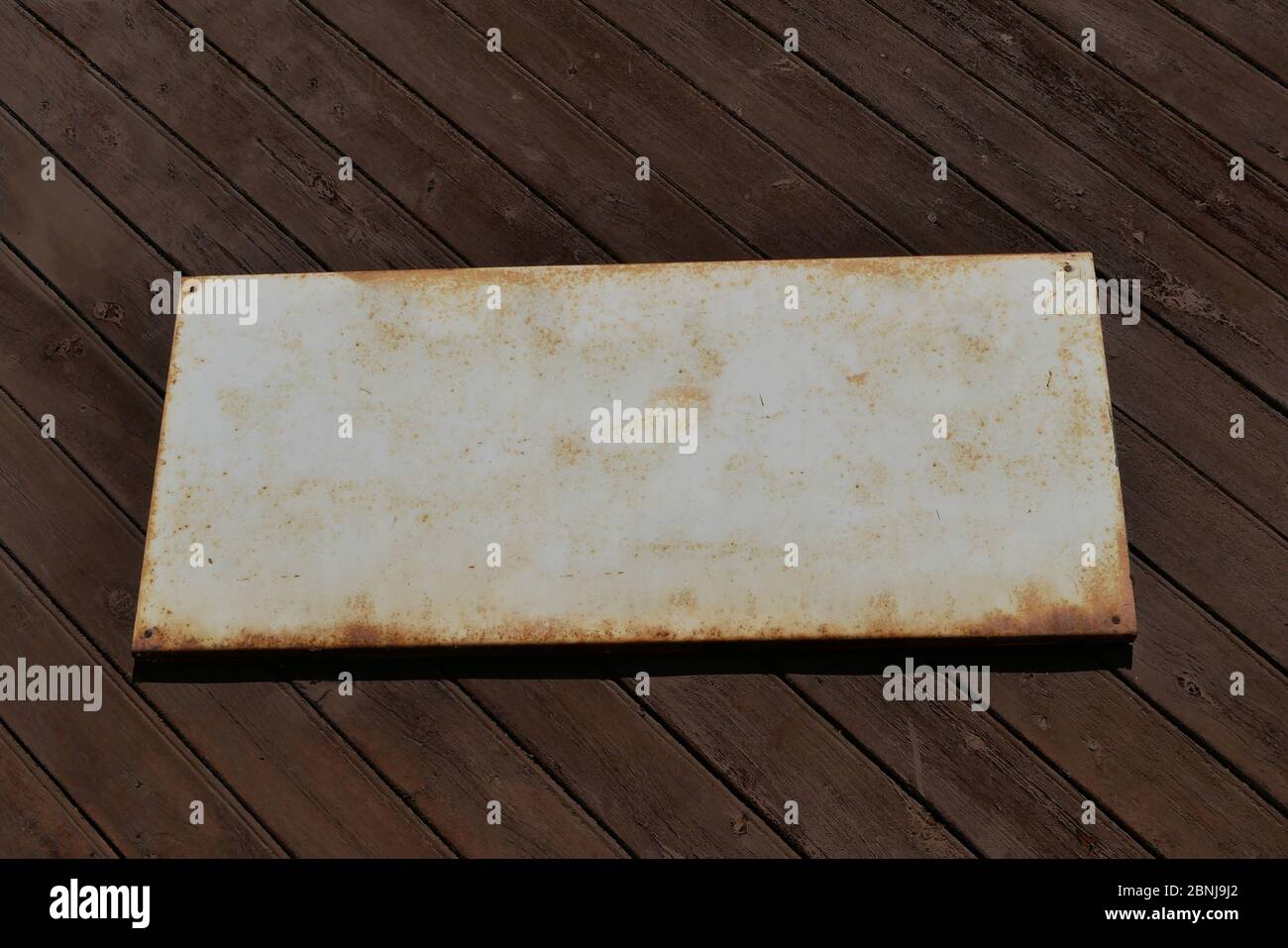 Vecchio cartello di stagno per modello di testo su un vecchio muro di legno. Foto Stock