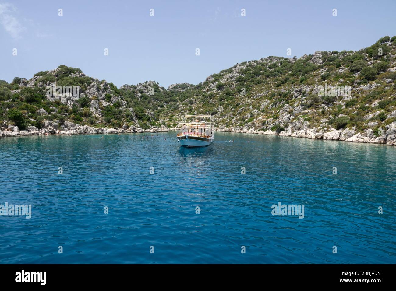 Kalekoy, Demre, Turchia - 03 giugno 2019: Turisti in piscina vicino al yacht da diporto. La costa rocciosa dell'isola di Kekova nel Mar Mediterraneo Foto Stock