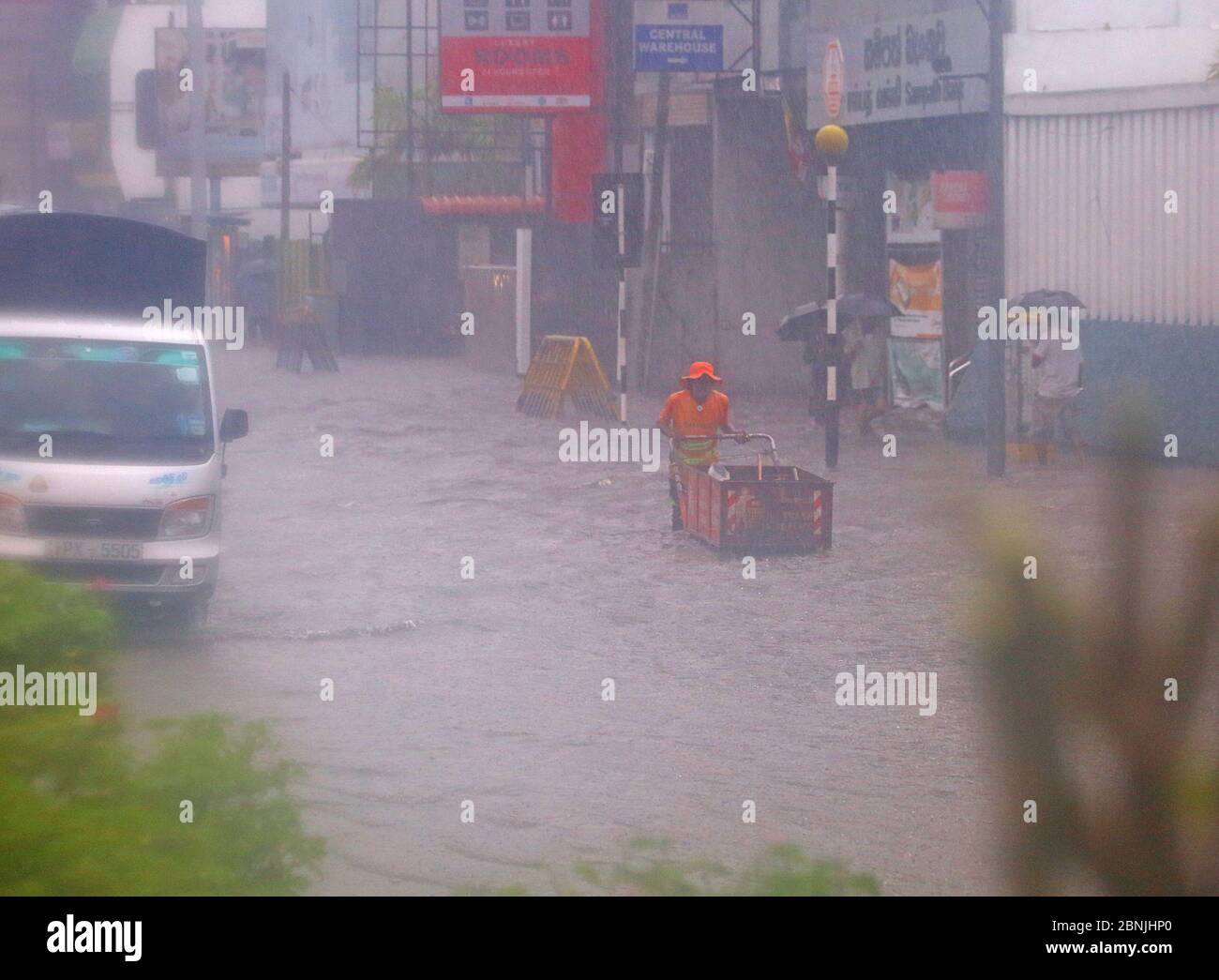Colombo, provincia occidentale, Sri Lanka. 15 maggio 2020. Un uomo spinge il suo carro attraverso una strada allagata durante una pesante caduta di pioggia a Colombo, Sri Lanka il 15 maggio 2020. Secondo il Dipartimento meteorologico, l'area a bassa pressione è ancora perdurata sulla baia sud-orientale del Bengala e adiacente al mare delle Andamane meridionali. E predicano la condizione di showery nella parte sud-occidentale è probabile che aumenti durante i prossimi giorni da oggi accreditamento: Dambarage di Pradeep/filo DI ZUMA/notizie in tensione di Alamy Foto Stock