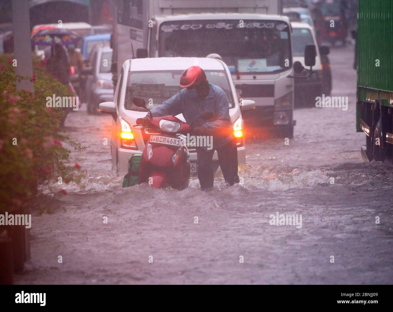 Colombo, provincia occidentale, Sri Lanka. 15 maggio 2020. Un uomo spinge la sua moto attraverso una strada allagata durante una forte pioggia a Colombo, Sri Lanka, il 15 maggio 2020. Secondo il Dipartimento meteorologico, l'area a bassa pressione è ancora perdurata sulla baia sud-orientale del Bengala e adiacente al mare delle Andamane meridionali. E predicano la condizione di showery nella parte sud-occidentale è probabile che aumenti durante i prossimi giorni da oggi accreditamento: Dambarage di Pradeep/filo DI ZUMA/notizie in tensione di Alamy Foto Stock