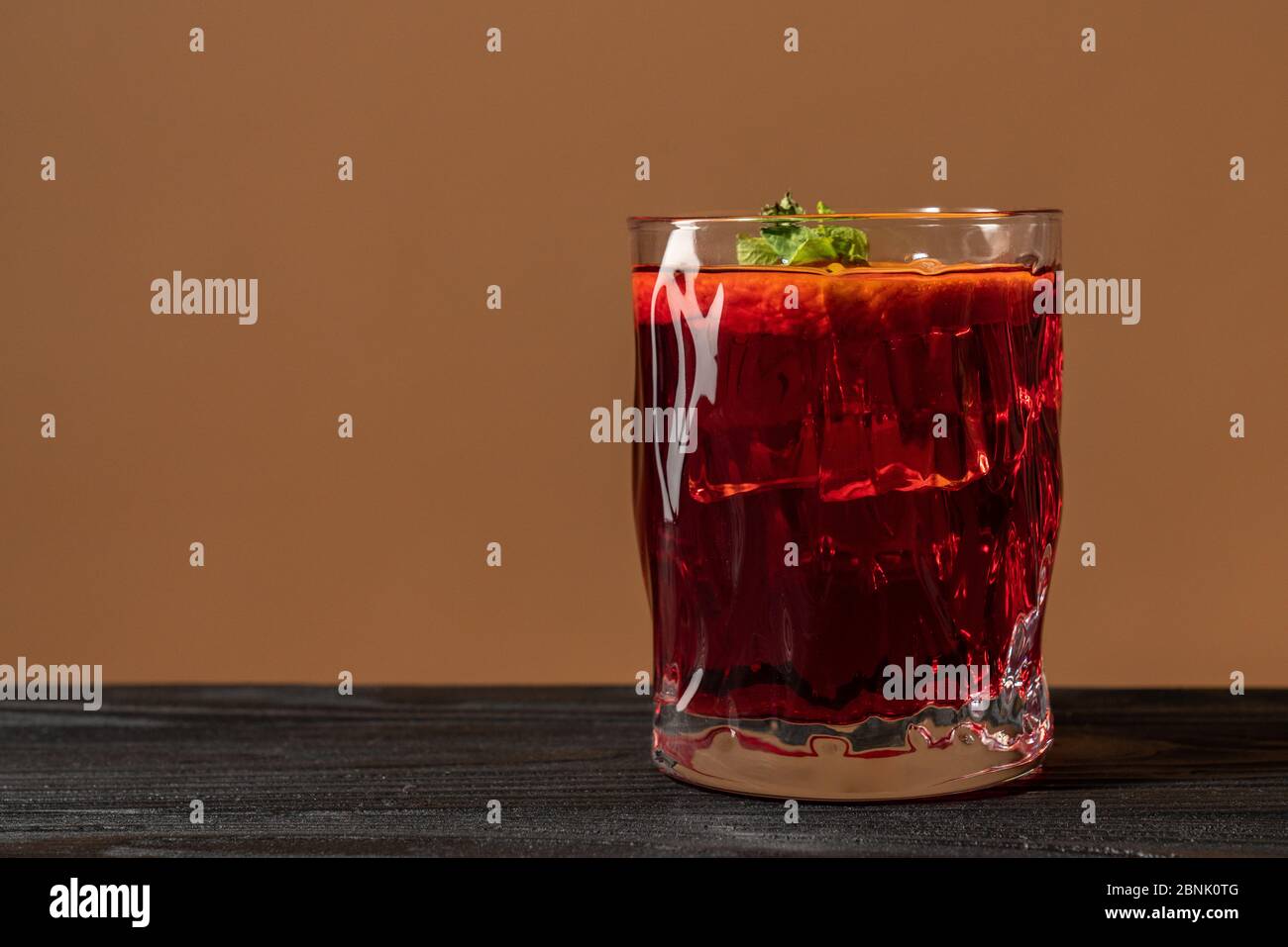 Bicchiere di rum sul tavolo di legno, Cuba Libre o cocktail di tè freddo a lunga isola con bevande forti e arancia a fette Foto Stock
