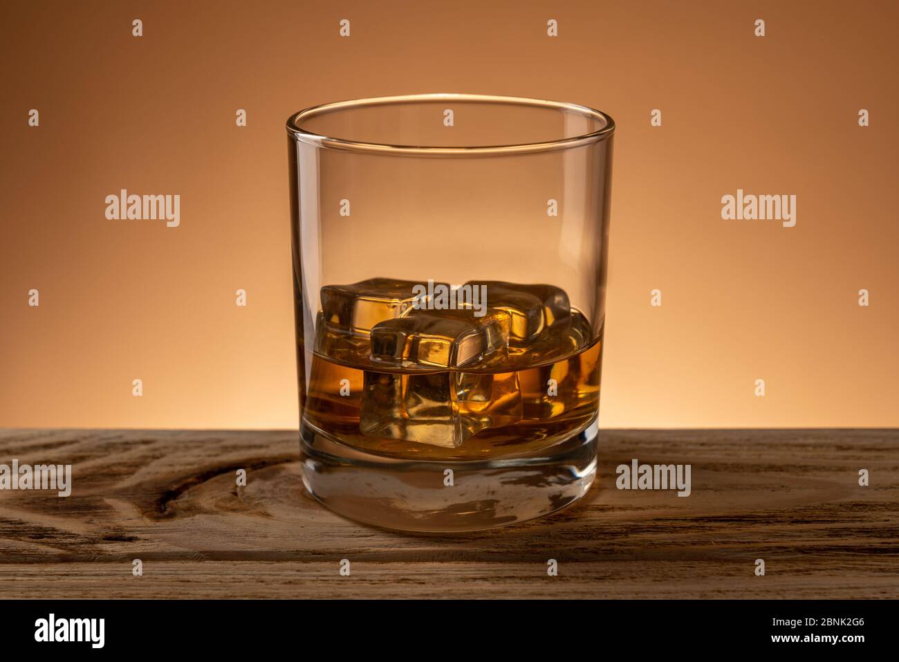 Bicchiere di whisky scotch con ghiaccio naturale su tavolo in legno al bar Foto Stock