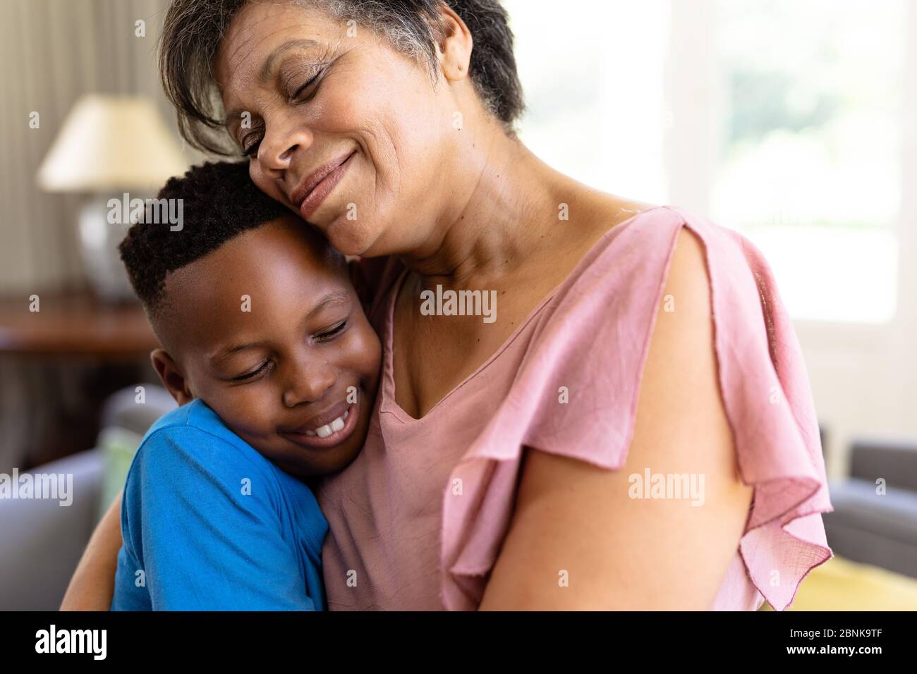 La donna di razza mista senior e suo nipote godendo il loro tempo a casa Foto Stock