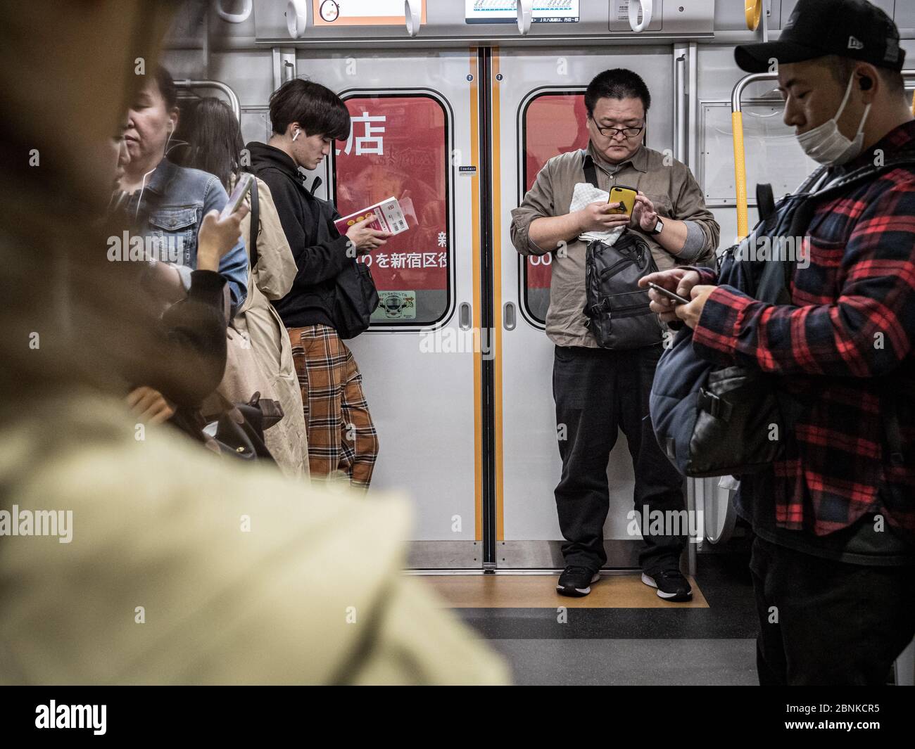 Tokyo, Giappone - 10.11.19: Persone che aspettano su un treno per pendolari molto affollato Foto Stock