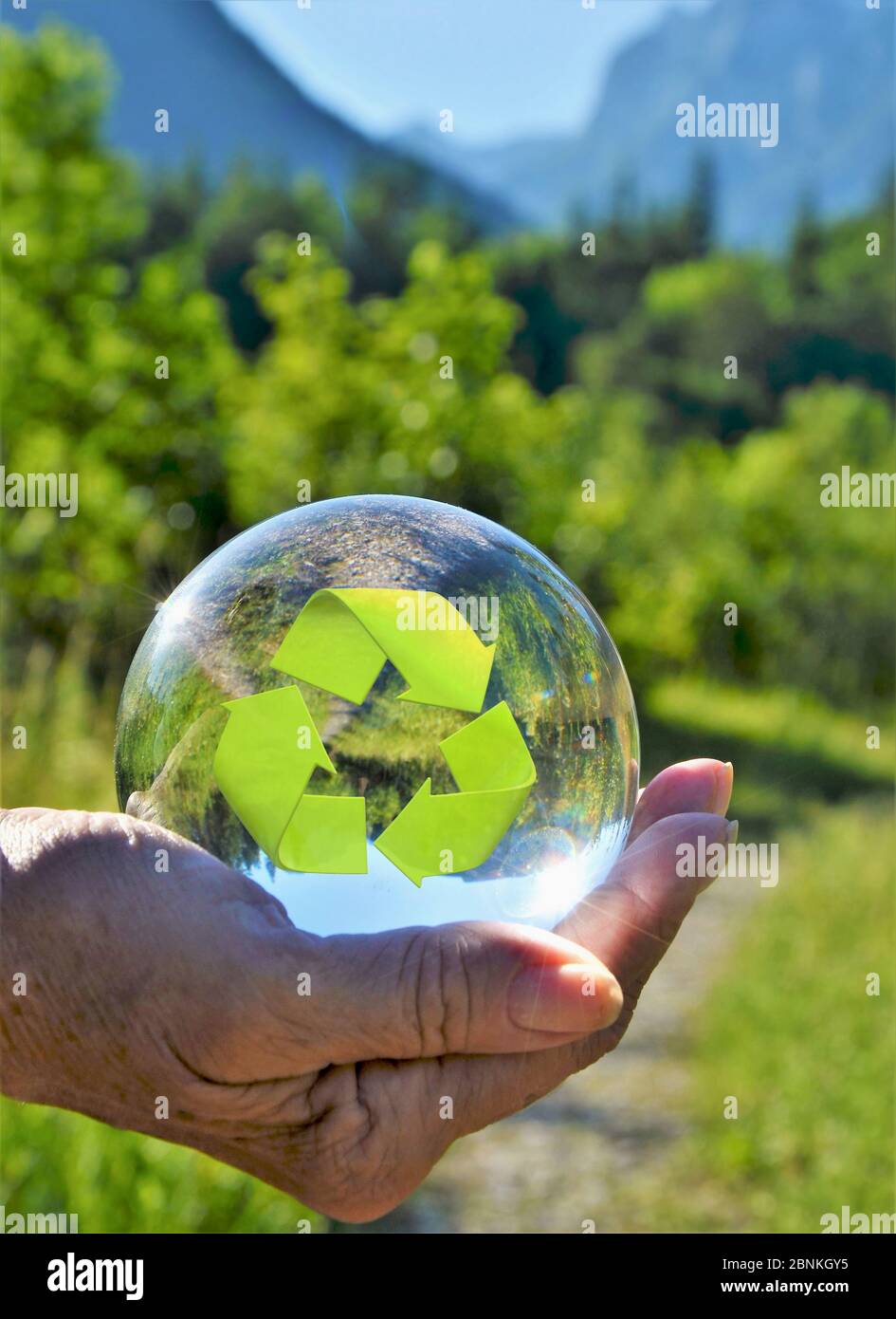 mano con simbolo di reyecling a sfera in vetro Foto Stock