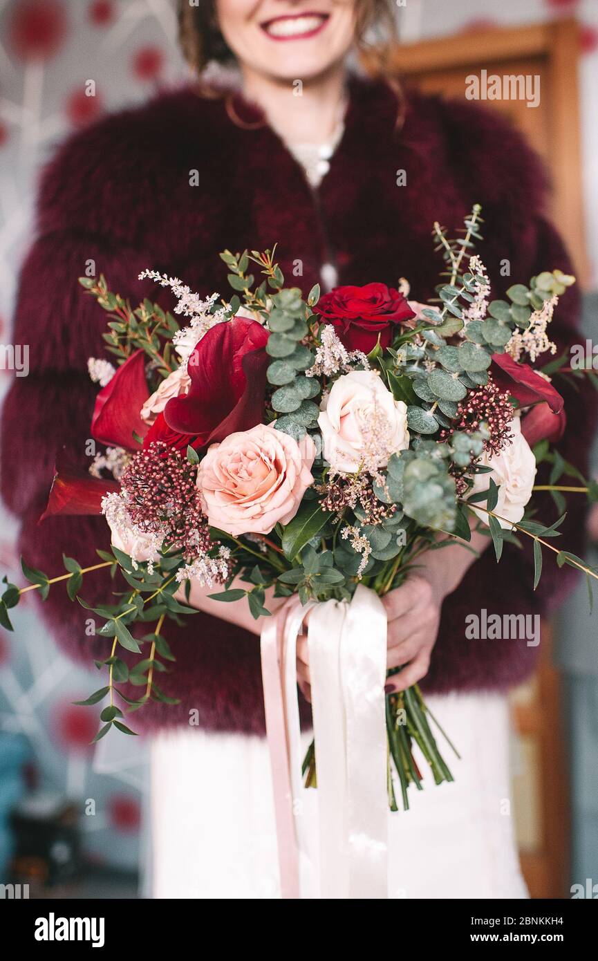 Primo piano bouquet di sposa, il bouquet è composto da rose rosse e bianche e eucalipto. La sposa tiene il bouquet Foto Stock