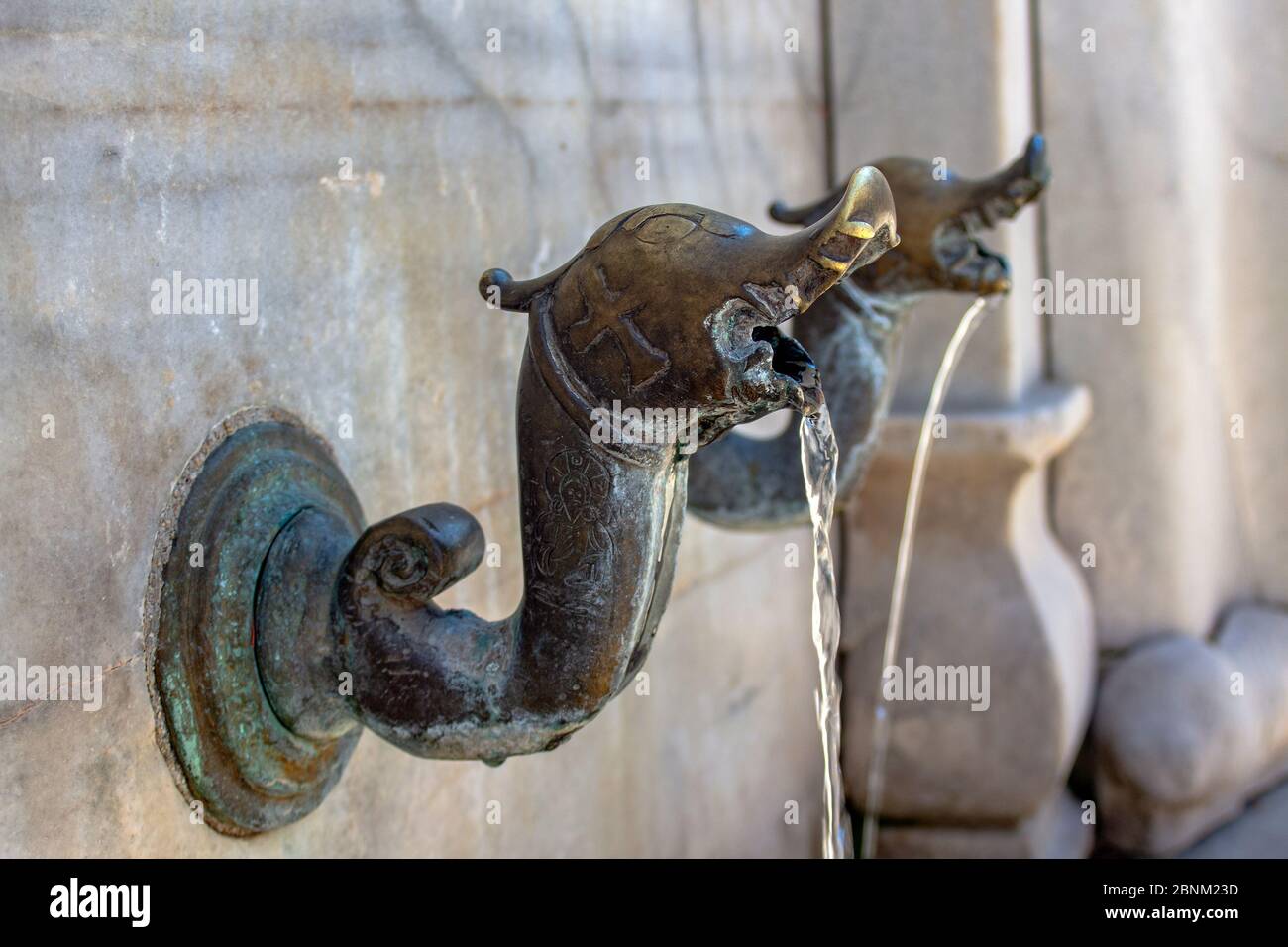 Rubinetto d'acqua in metallo medievale con elementi religiosi e forma di drago. Foto Stock