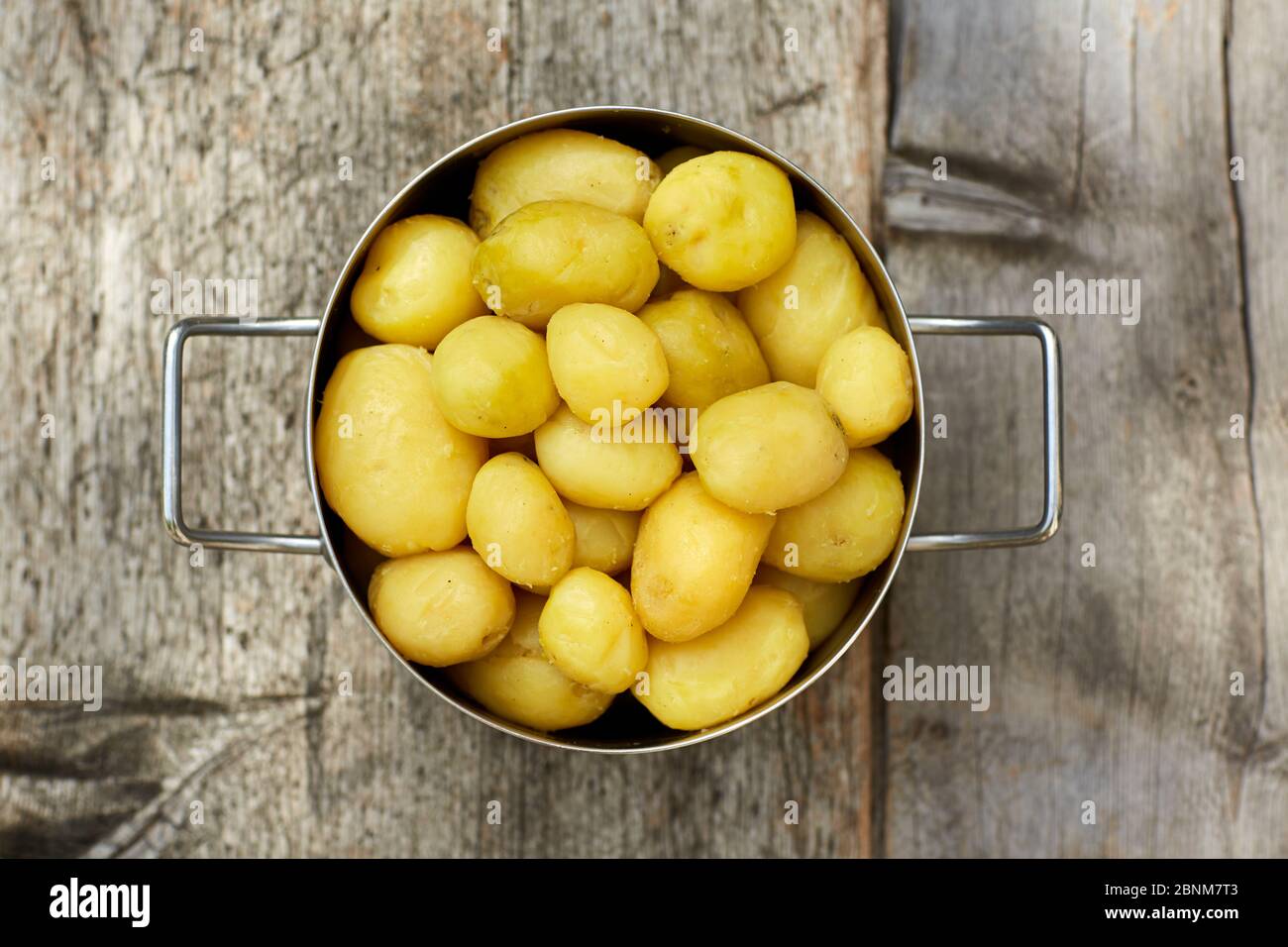 Pentola da cucina, patate, sbucciata, tavola di legno, supervisione Foto Stock