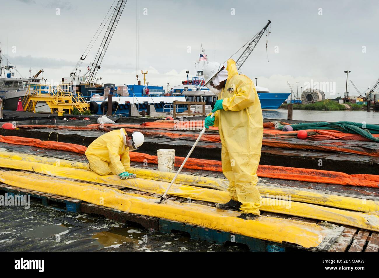 Gli uomini di olio di pulizia barriere di contenimento durante Deepwater Horizon fuoriuscite di olio, Louisiana, Golfo del Messico, USA, Agosto 2010 Foto Stock