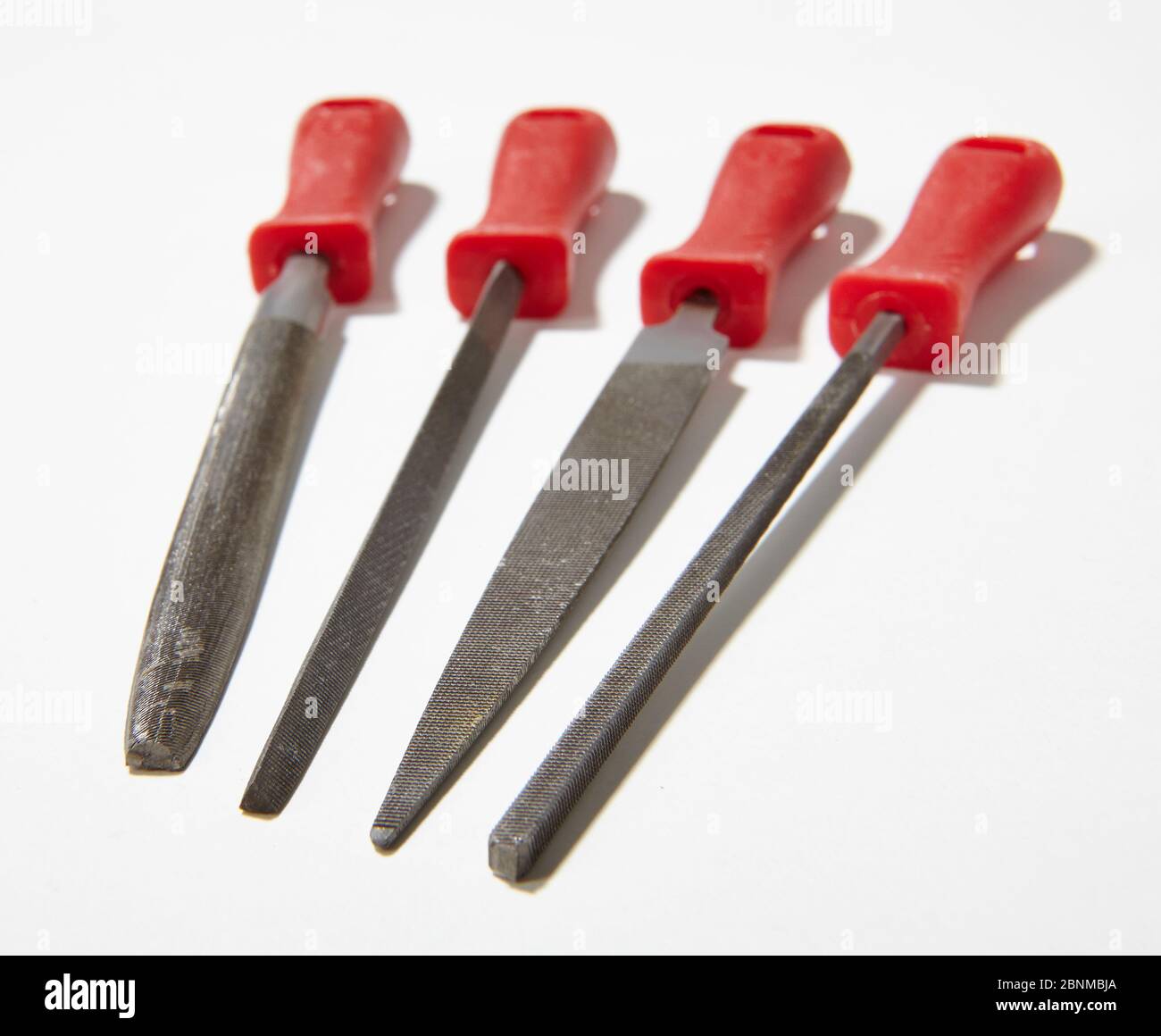 Strumento per la lavorazione del metallo, serie, immagine 5 di 7, 4 lime metalliche con manico rosso, registrazione di oggetti su sfondo bianco Foto Stock