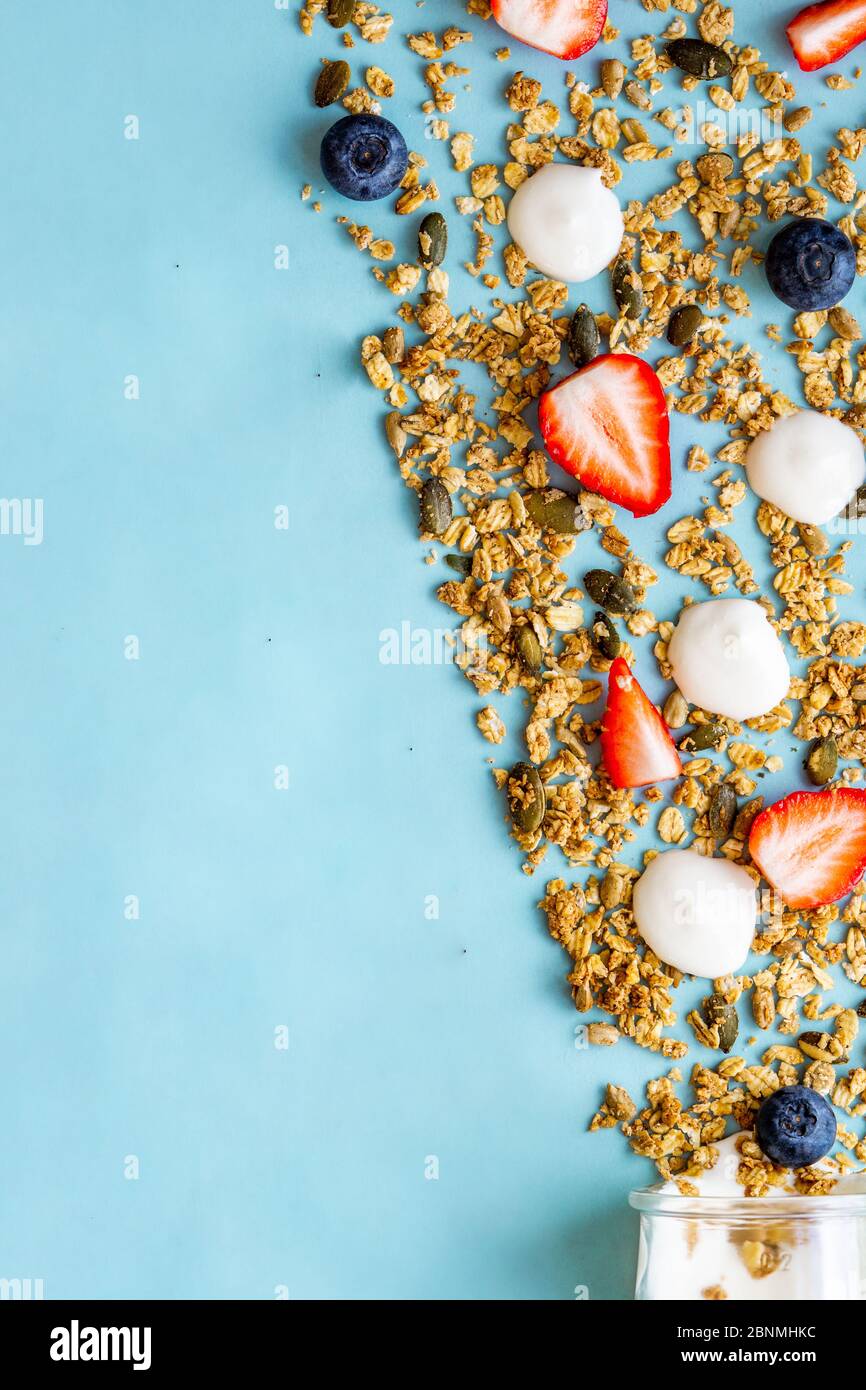 Foto creativa di yogurt con muesli, mirtilli, fragole. Sana colazione vegetariana o spuntino. Spazio di copia, vista dall'alto. Foto Stock