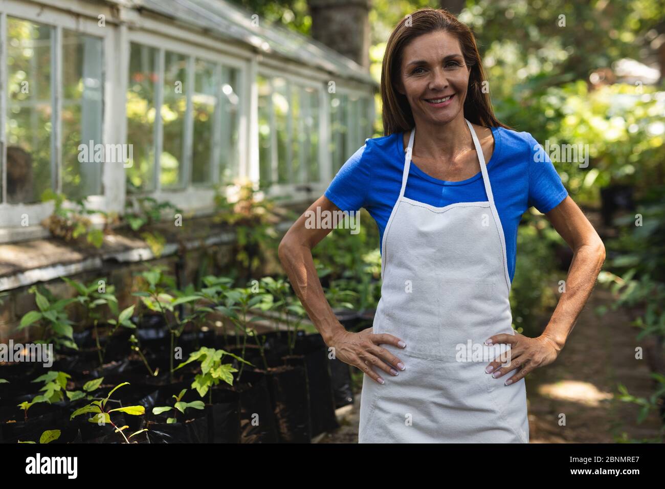 Una donna caucasica in piedi in una serra. Foto Stock