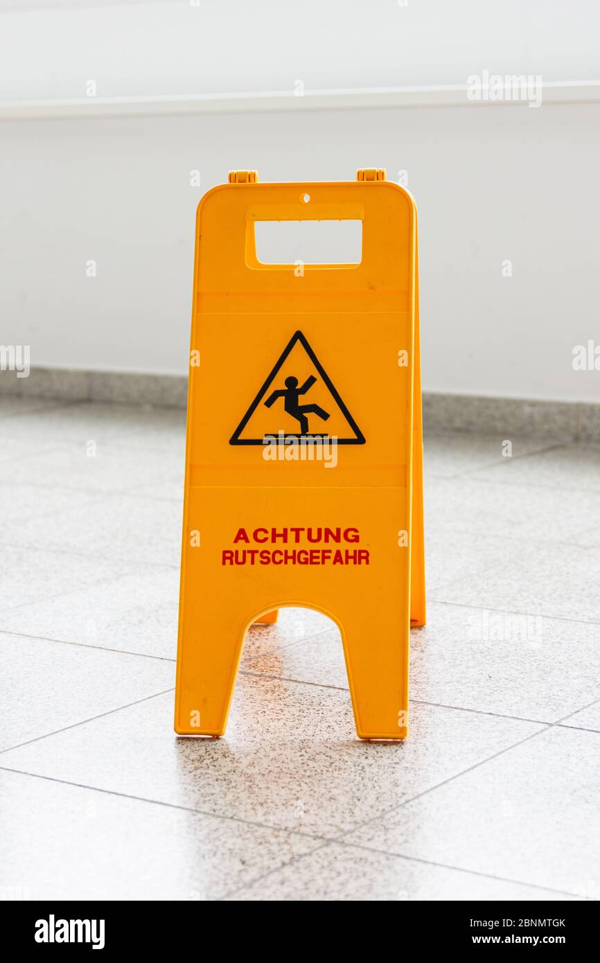 Attenzione pavimento bagnato o pulizia in corso. Un segno giallo avverte di pericolo. Foto Stock