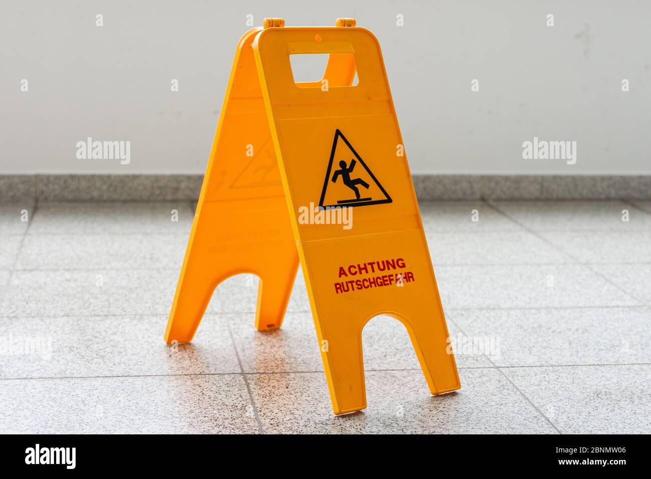 Attenzione pavimento bagnato o pulizia in corso. Un segno giallo avverte di pericolo. Foto Stock