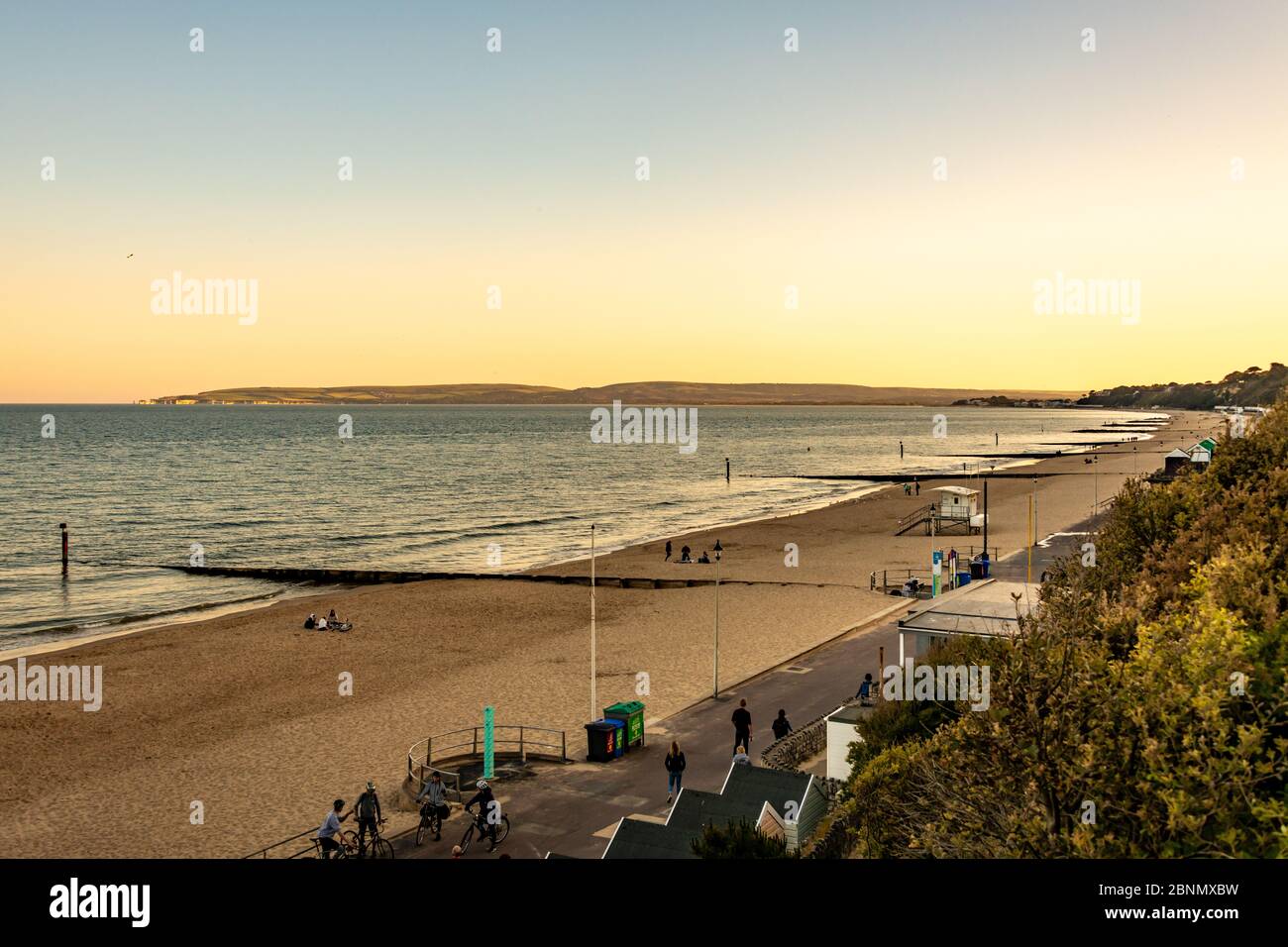 Bournemouth, Regno Unito. Venerdì 15 maggio 2020. La gente visita la spiaggia al tramonto con qualche divaricamento sociale a Bournemouth, Regno Unito. Persone a piedi e a cavallo sulla passeggiata e spiaggia di sabbia. Credit: Thomas Faull/Alamy Live News Foto Stock