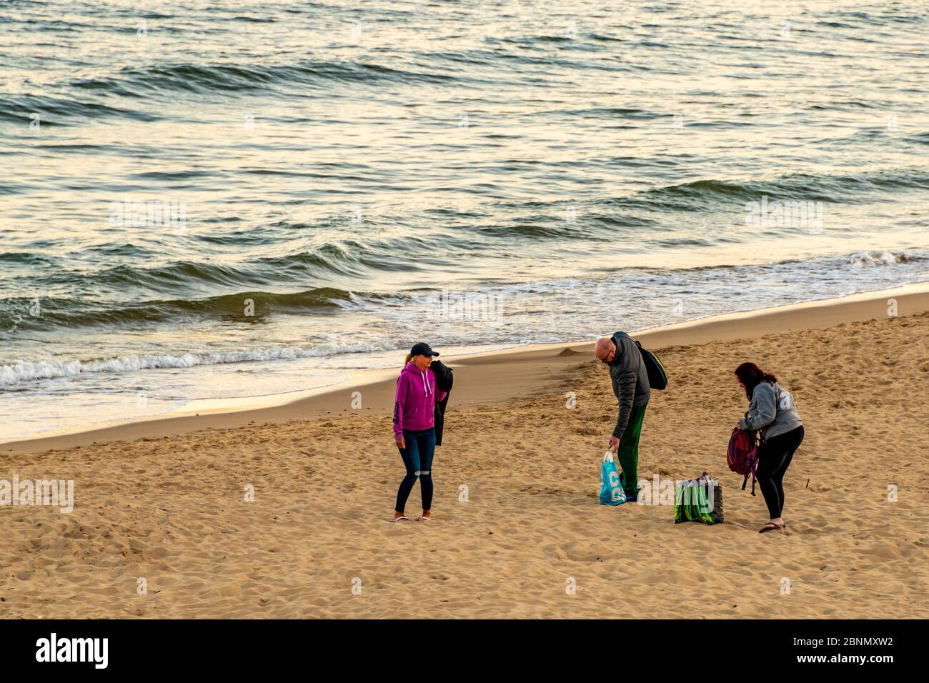 Bournemouth, Regno Unito. Venerdì 15 maggio 2020. La gente visita la spiaggia al tramonto con qualche divaricamento sociale a Bournemouth, Regno Unito. Persone a piedi e a cavallo sulla passeggiata e spiaggia di sabbia. Credit: Thomas Faull/Alamy Live News Foto Stock