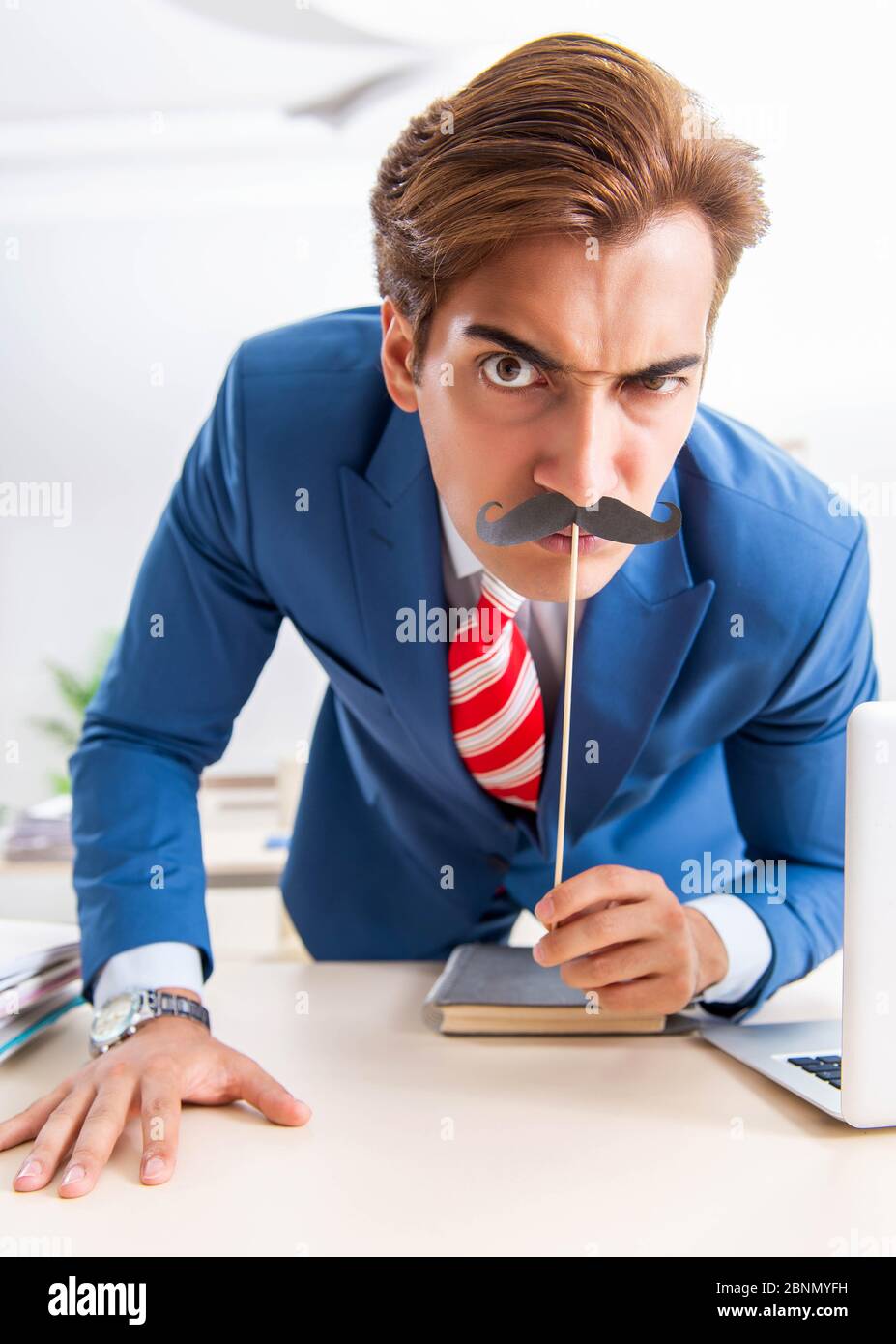 La divertente bisinessman con baffi finti in ufficio Foto Stock