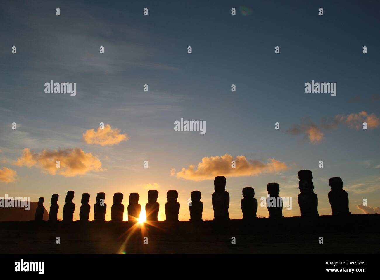 Il sole sorge attraverso AHU Tongariki, la più grande ahu dell'isola di Pasqua, il territorio insulare del Cile nell'Oceano Pacifico meridionale. Foto Stock