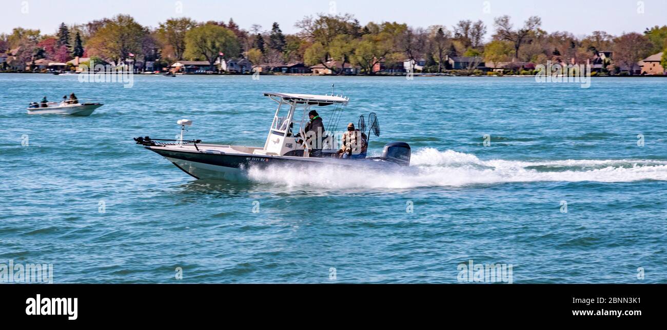 Detroit, Michigan - UNA barca di pesca sportiva accelera il fiume Detroit in una fredda mattina di primavera. Foto Stock