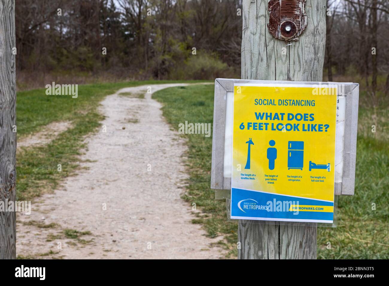 Washington Township, Michigan - UN cartello a Stony Creek Metropark ricorda agli escursionisti di rimanere la distanza sociale corretta durante il c Foto Stock
