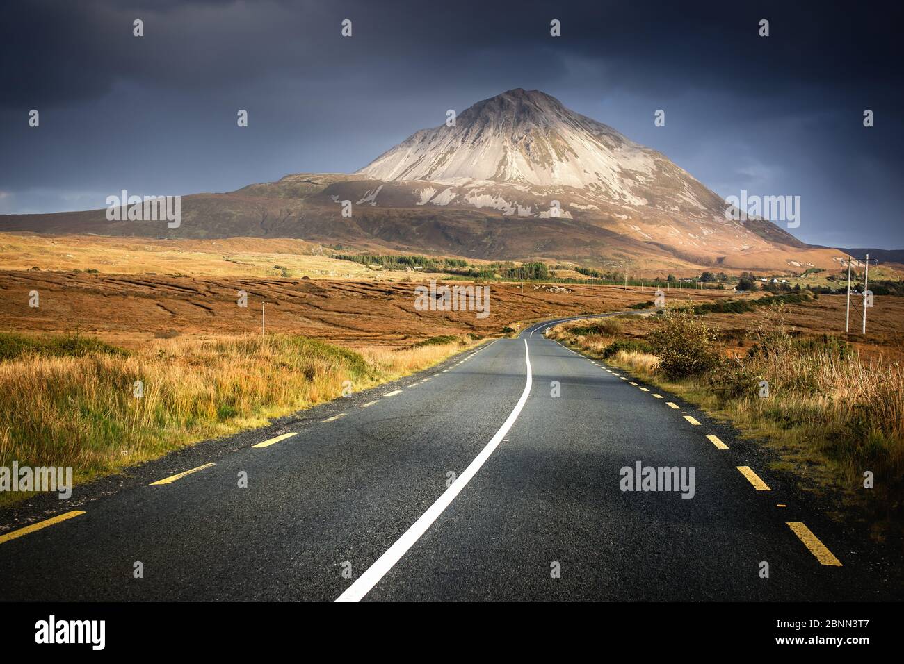 Irlanda, Irlanda del Nord, Monte Errigal alla luce della sera, strada attraverso la campagna Foto Stock