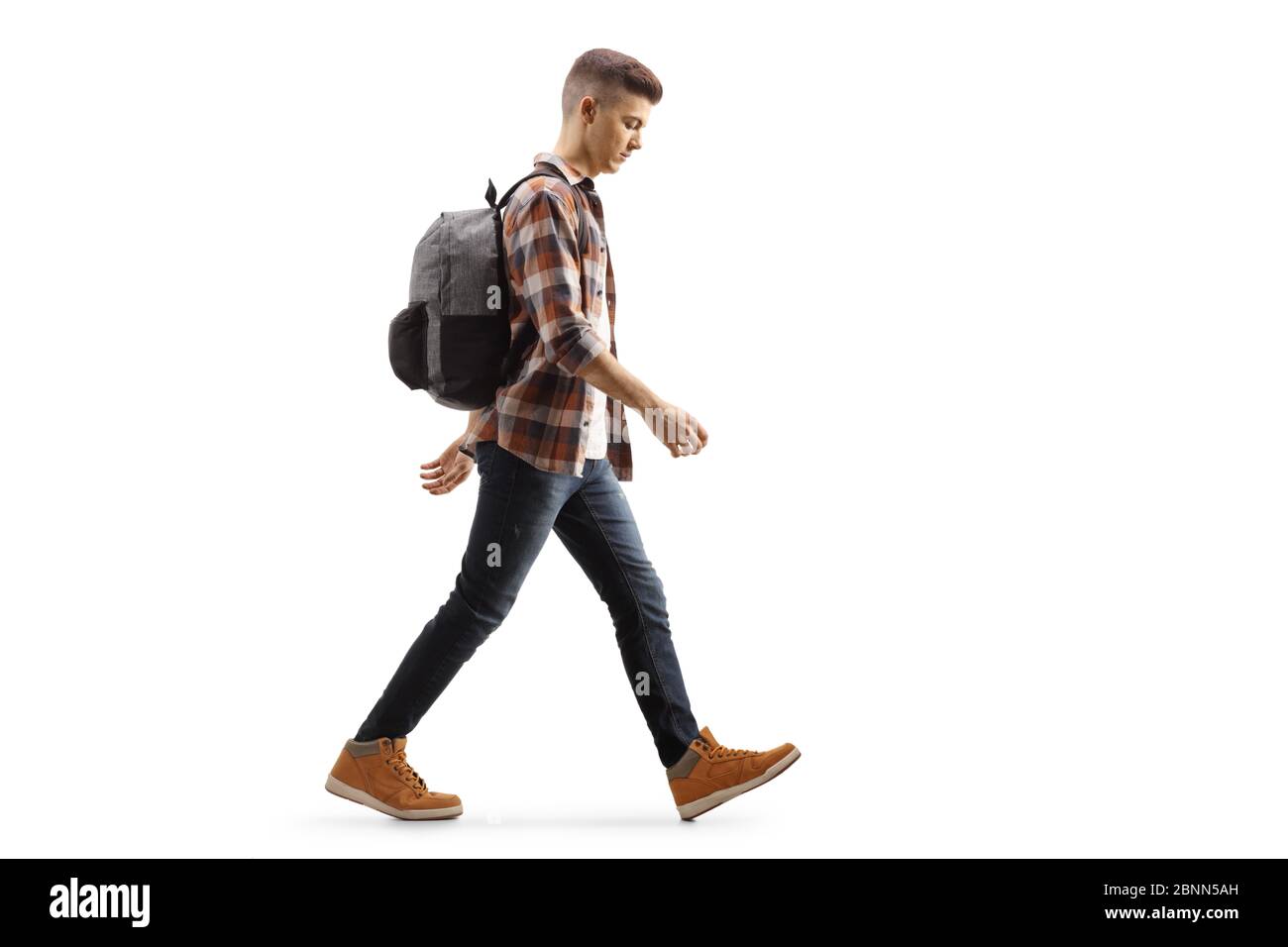 Foto di profilo di lunghezza completa di un triste studente adolescente maschile che cammina isolato su sfondo bianco Foto Stock