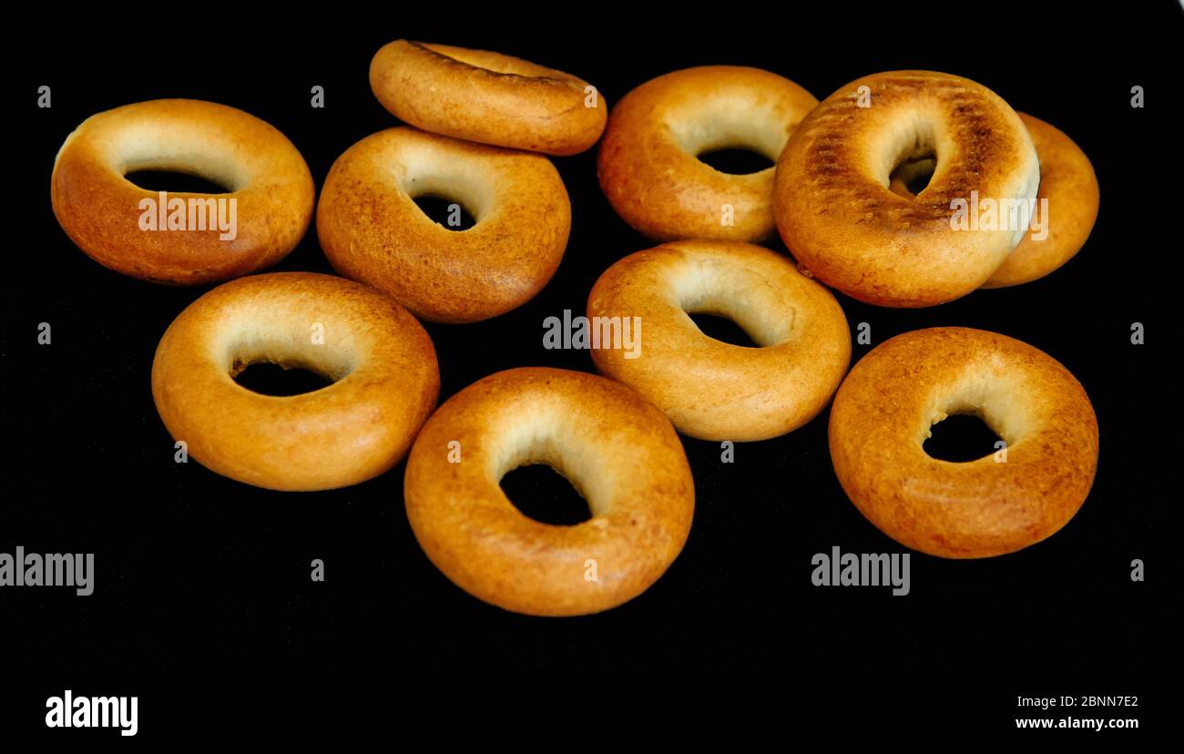 Bagel di colore dorato isolati su sfondo nero Foto Stock