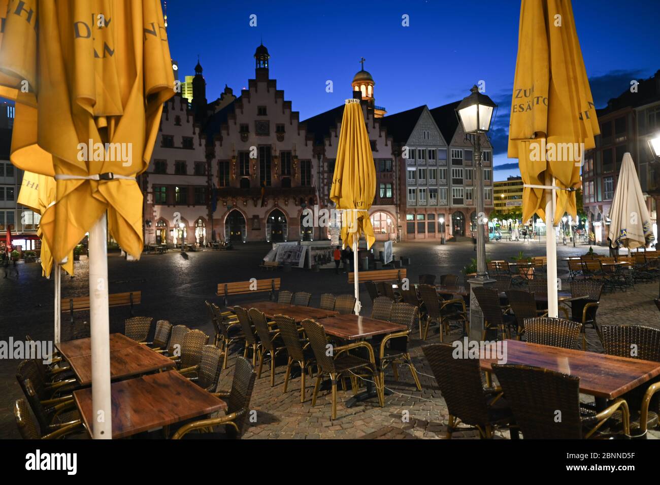 15 maggio 2020, Hessen, Francoforte sul meno: Tavoli e sedie vuote si trovano di fronte a un ristorante sulla Römerberg la sera dopo l'orario di chiusura. Foto: Arne Dedert/dpa Foto Stock