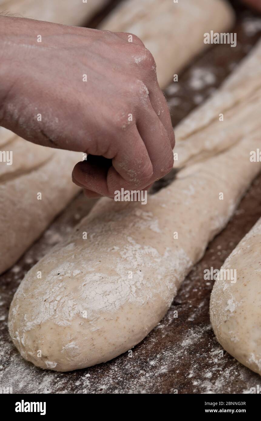 baker preparazione baguette alla panetteria Foto Stock