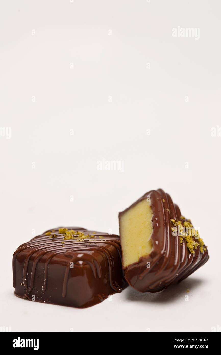 praline fatte a mano con ripieno di marzapane su fondo bianco Foto Stock