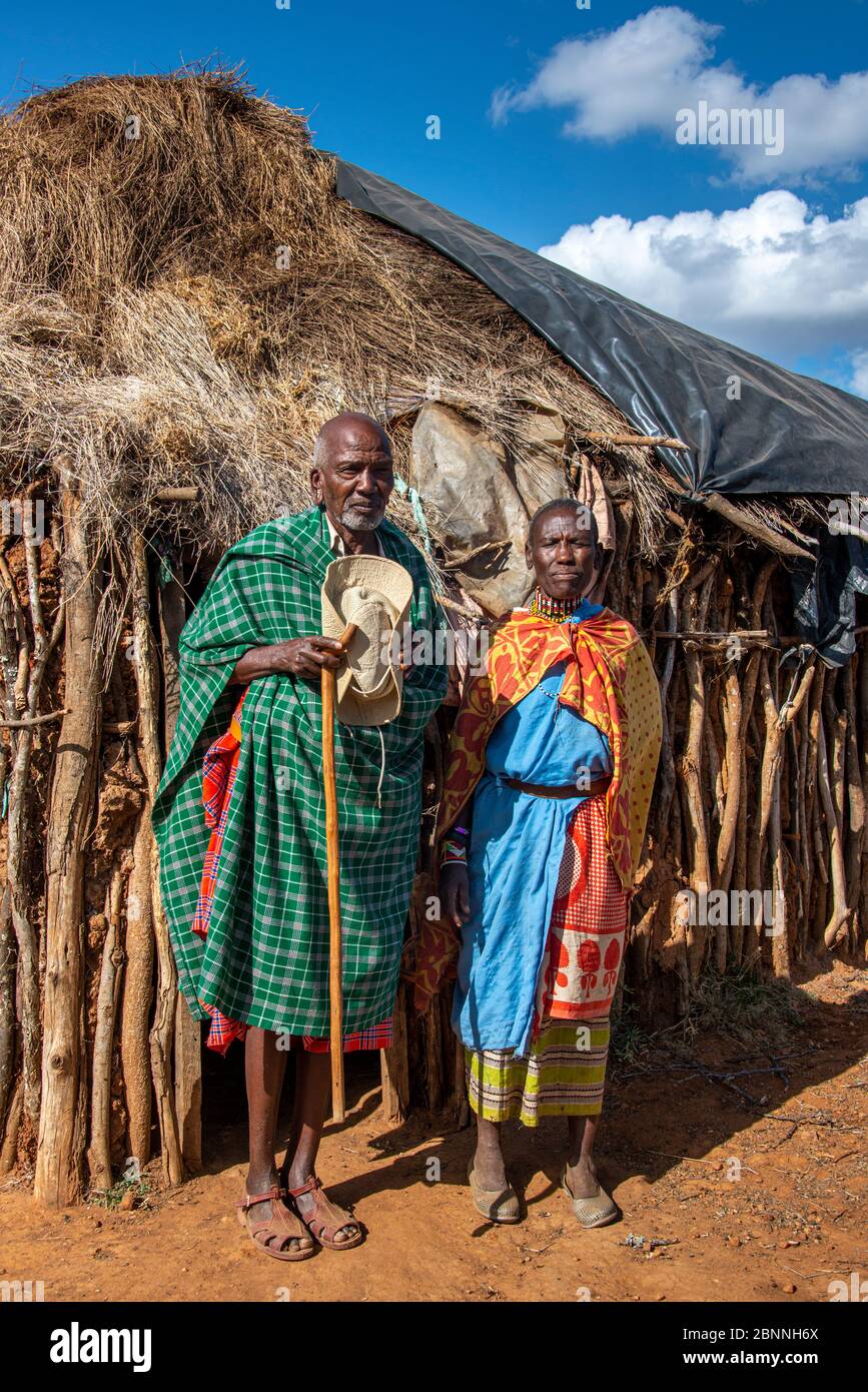 Coppia di vecchi Maasai vicino alla loro casa di fango Foto Stock
