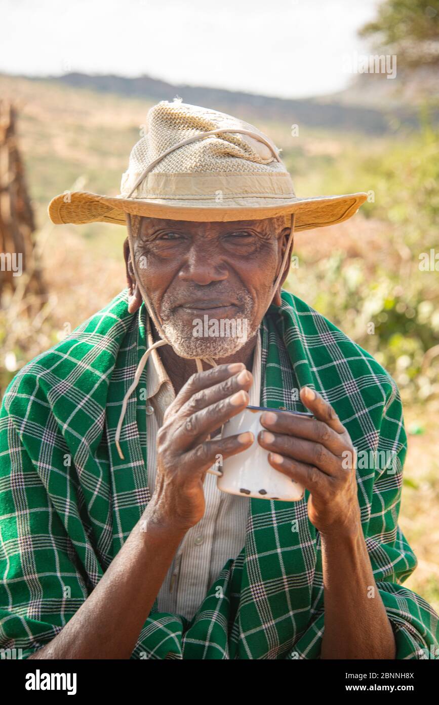 Uomo Maasai anziano che gusta il tè Foto Stock