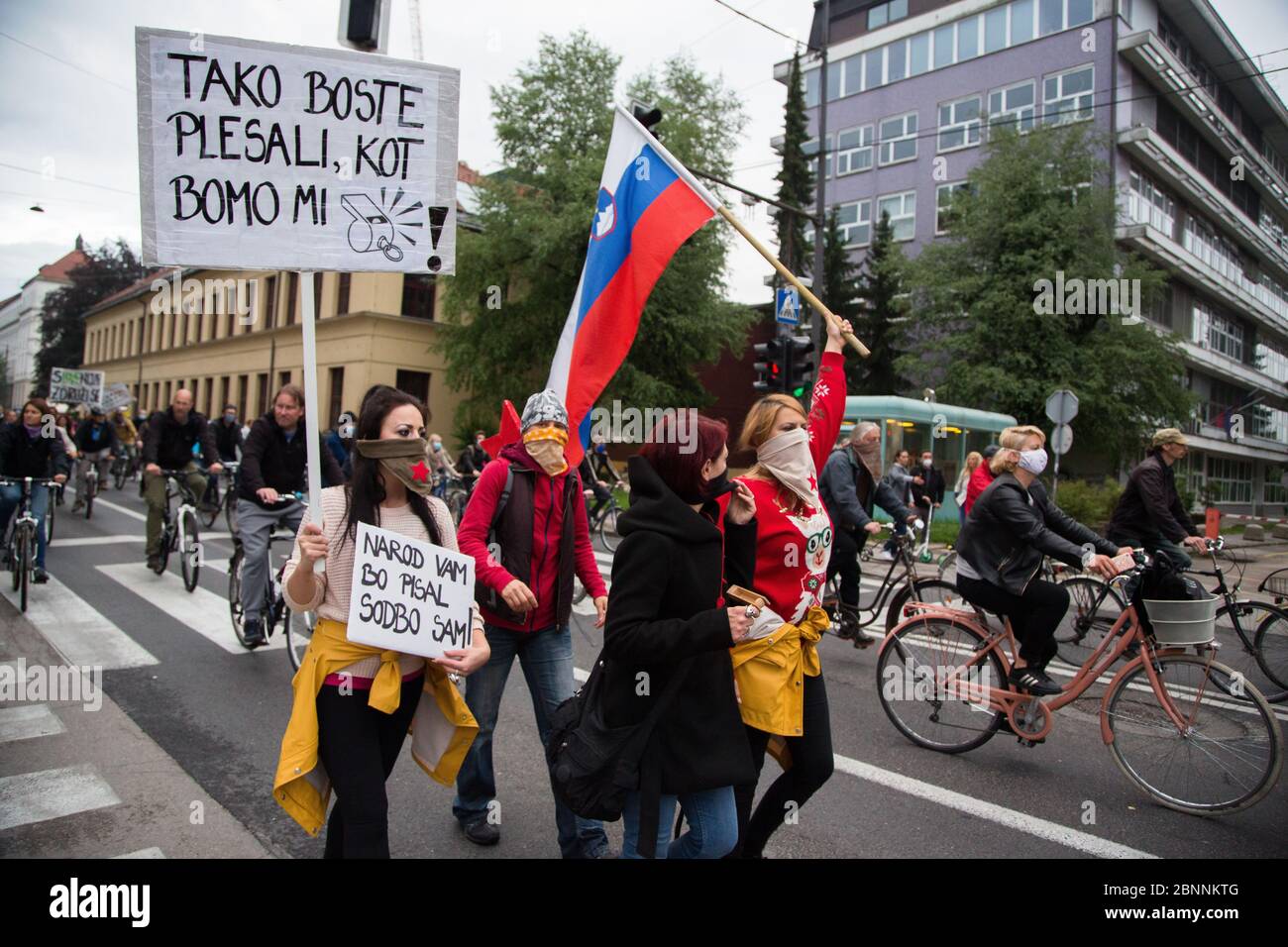 Un manifestante tiene cartelli durante la manifestazione.a seguito delle rivelazioni di corruzione del fischiatore nel governo di Janez Janša e delle accuse di suo governo antidemocratico, oltre cinquemila persone hanno vagato biciclette intorno agli edifici governativi in segno di protesta. Foto Stock