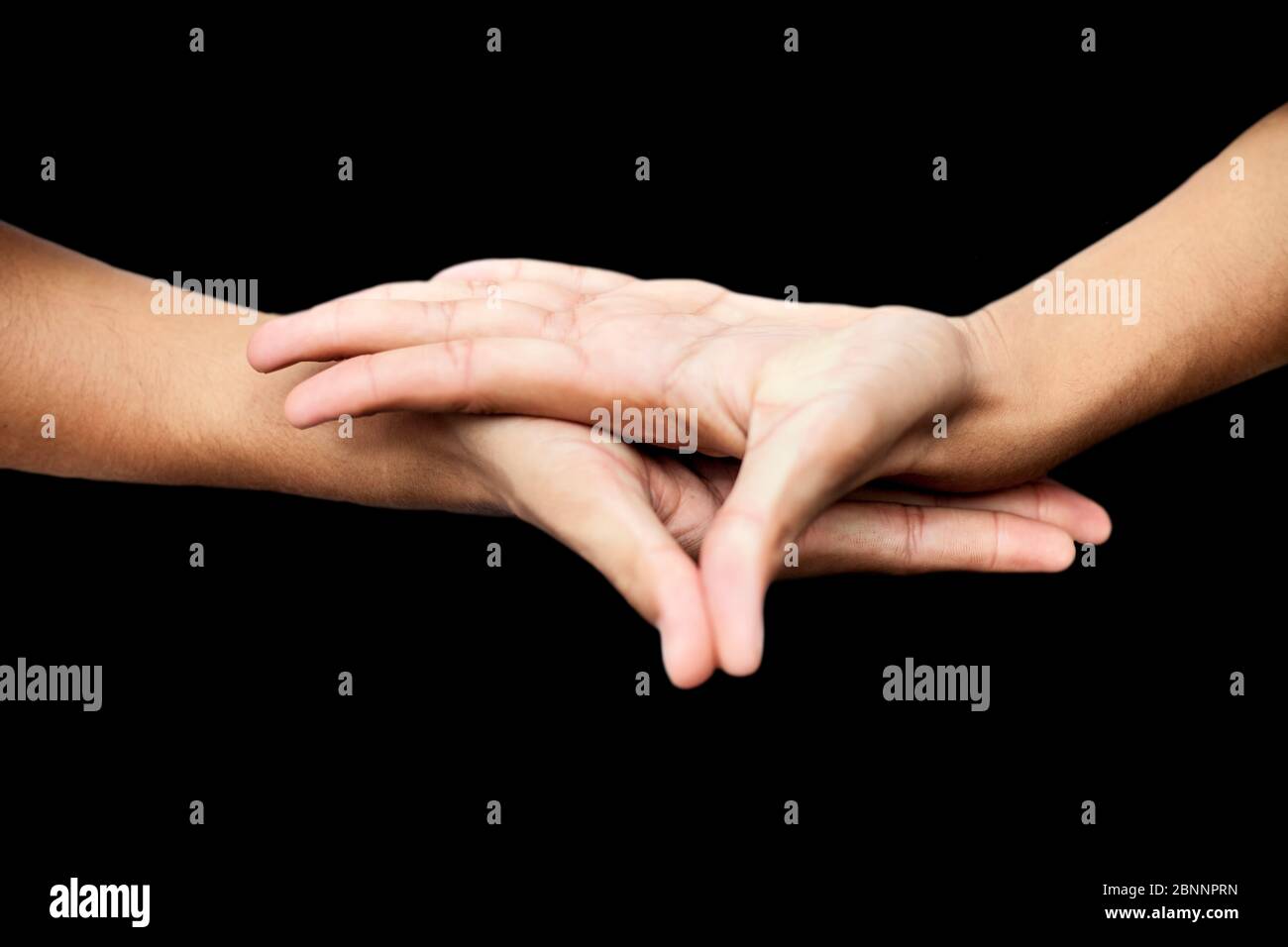 Primo piano di mani maschili che dimostrano Buddha Mudra su sfondo nero. Foto Stock